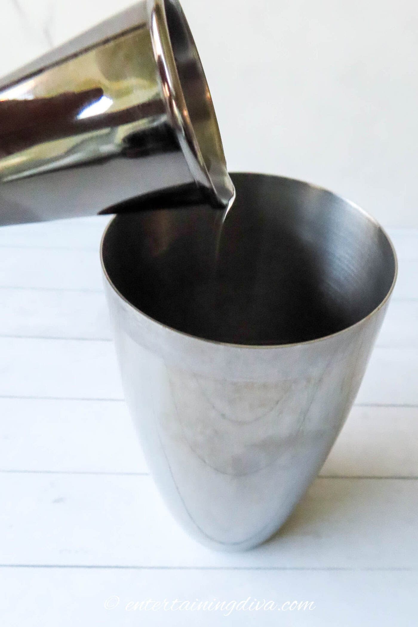 Vodka being poured into a cocktail shaker