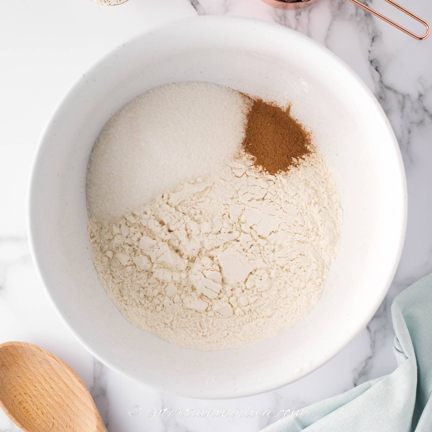 flour, sugar and pumpkin pie spice in a white mixing bowl