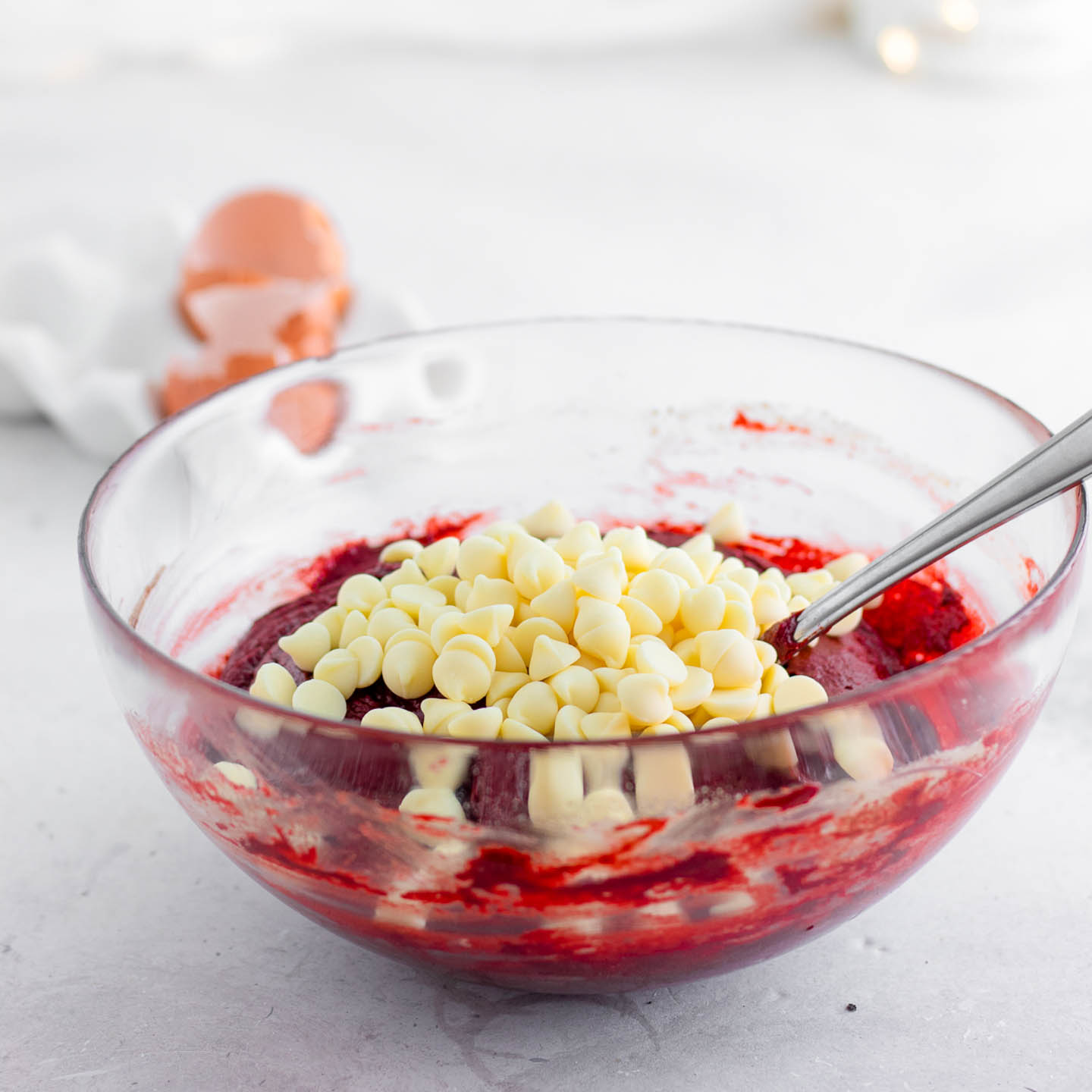 white chocolate chips in a bowl of red velvet cake mix