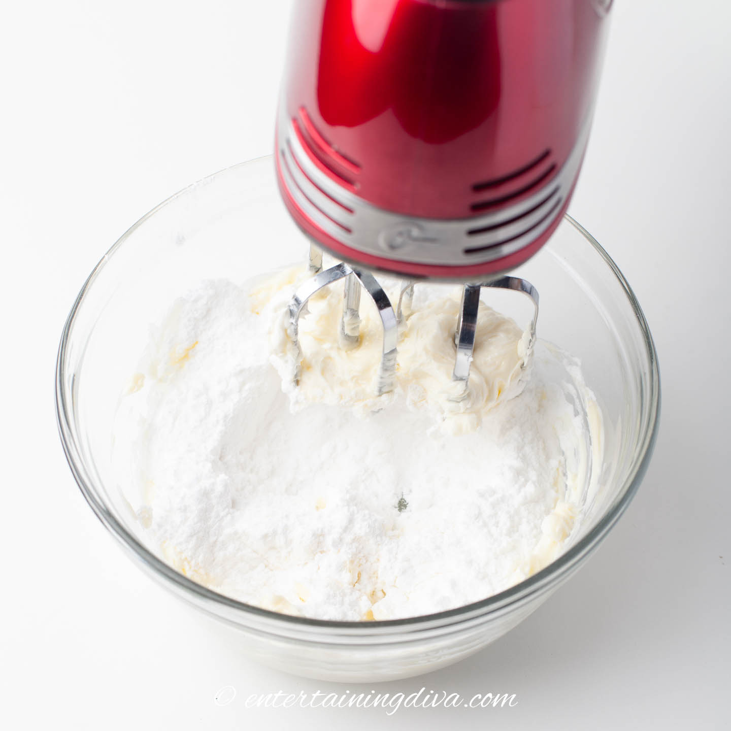 icing sugar being mixed into cream cheese frosting