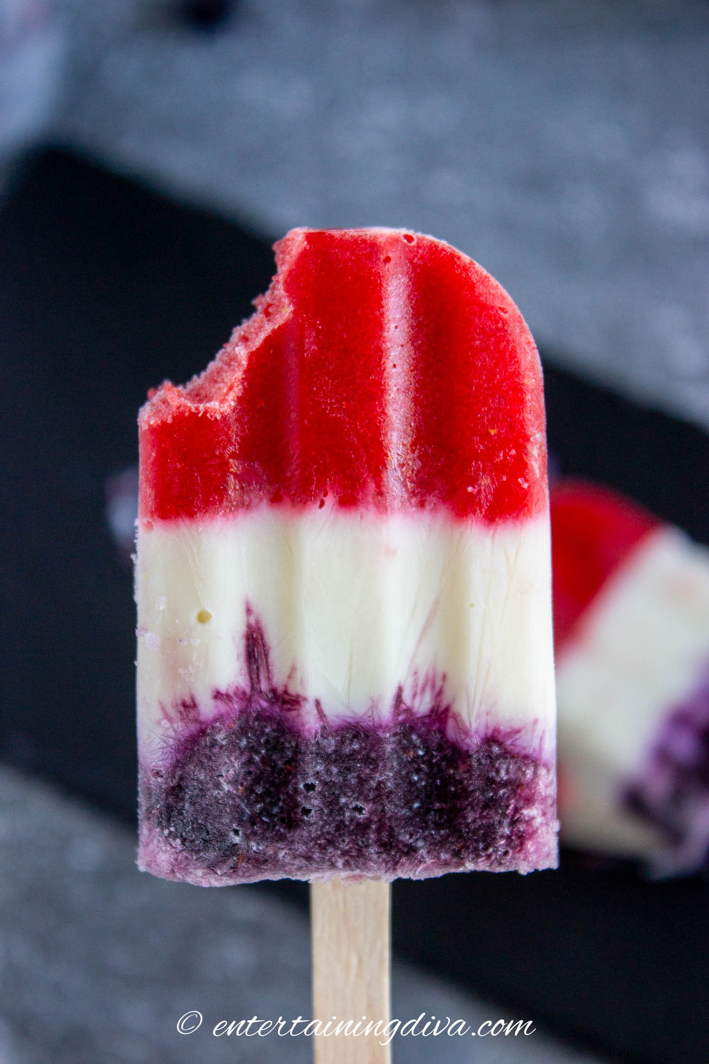A red white and blue popsicle with a bite out of one corner
