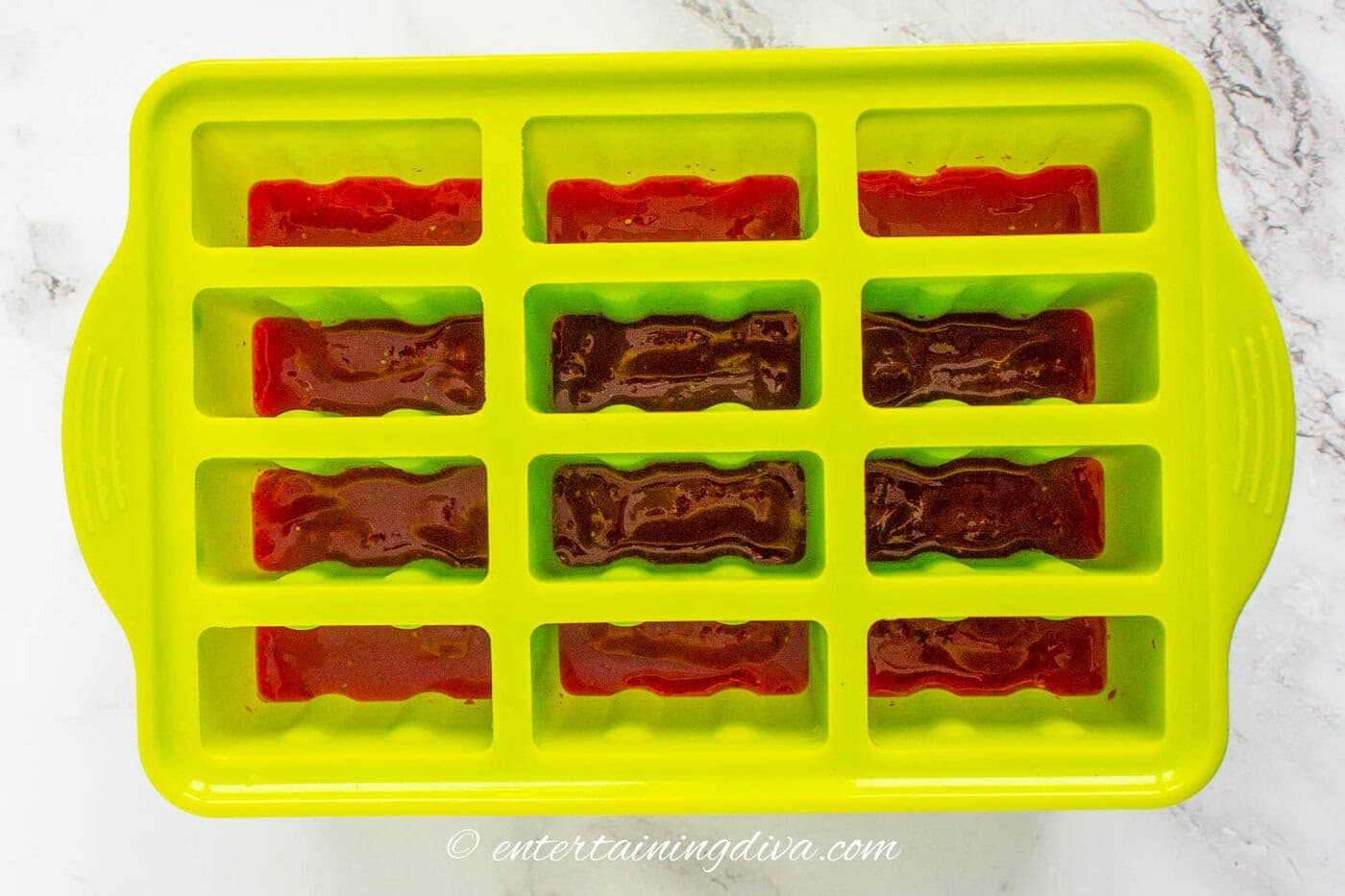 popsicle mold 1/3 full with blended strawberry mixture