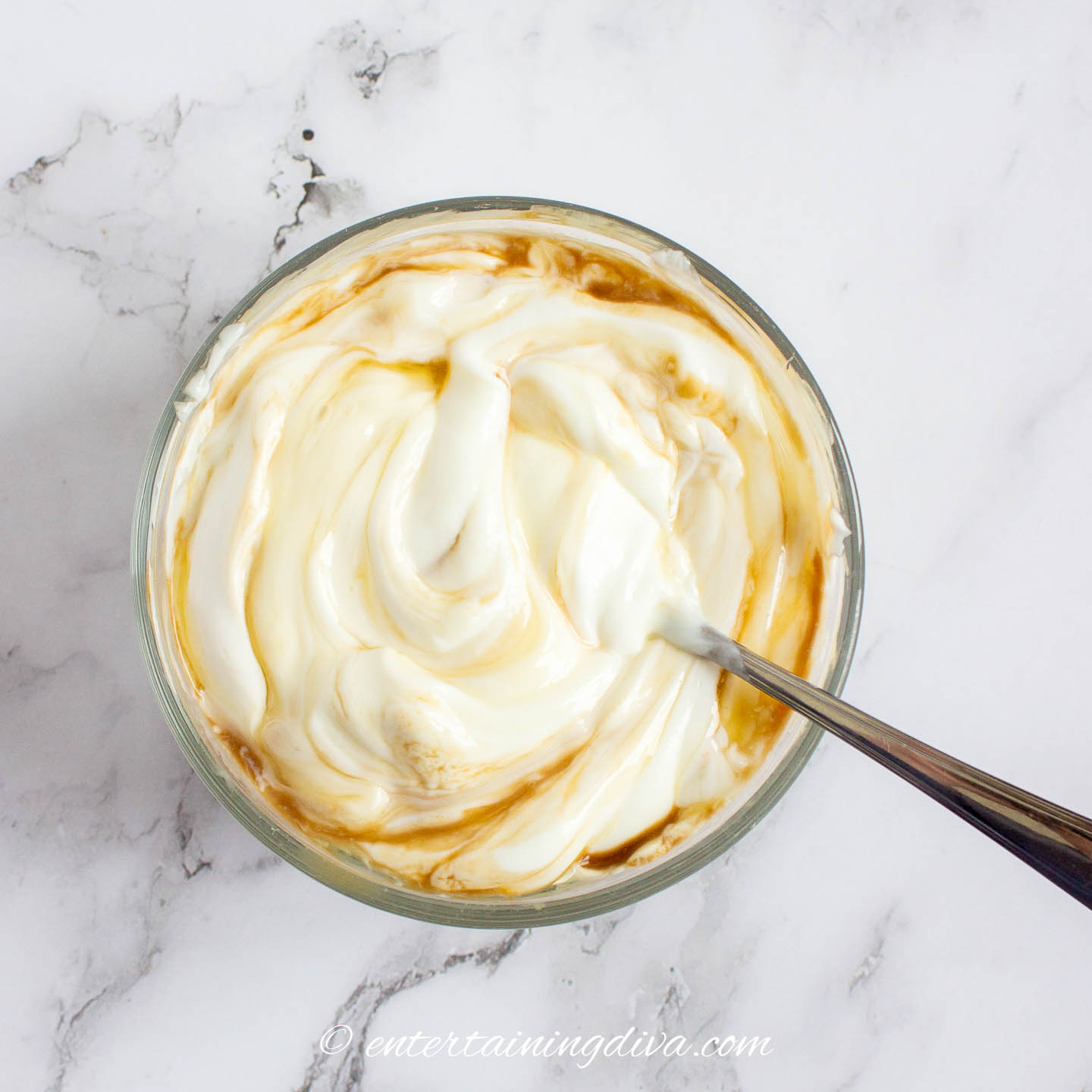Greek yogurt being mixed with honey and vanilla in a bowl