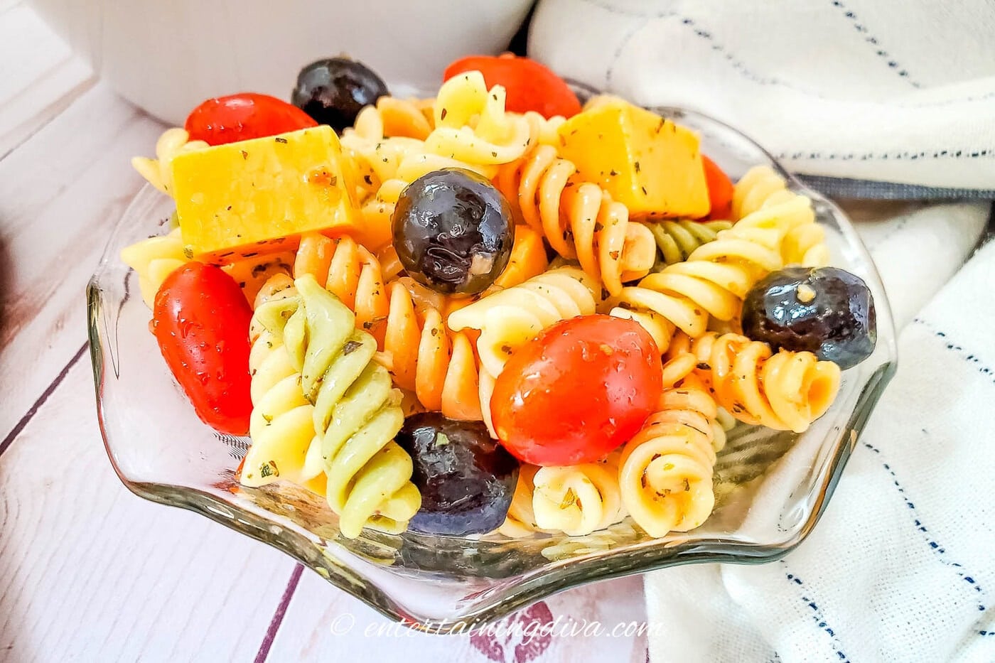 A side view of a bowl of Rotini pasta salad