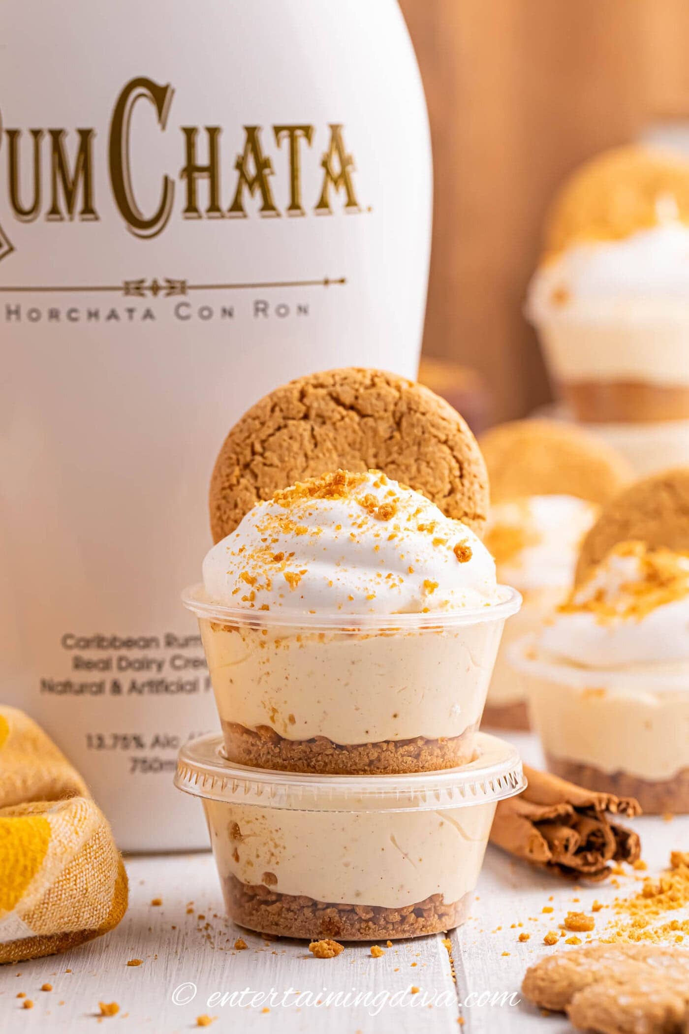 Two Gingerbread Christmas pudding shots stacked on top of each other in front of a RumChata bottle