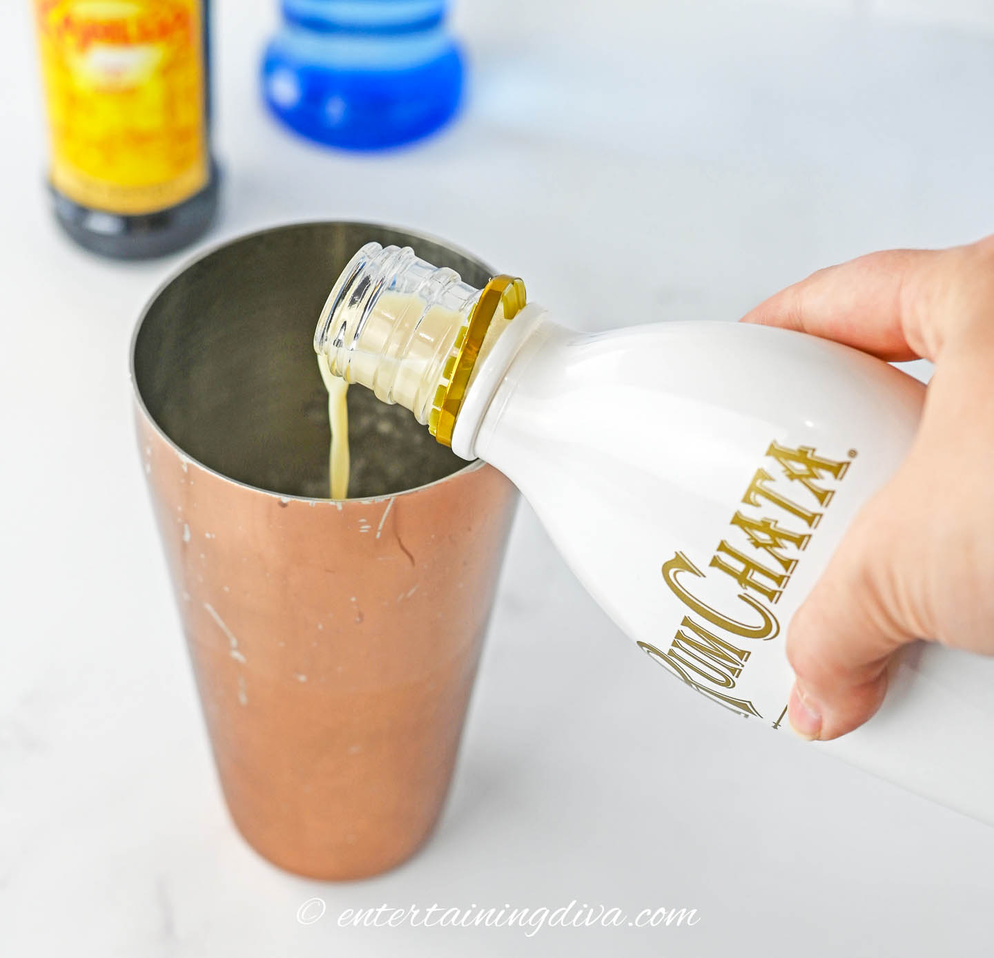 RumChata being poured into a cocktail shaker