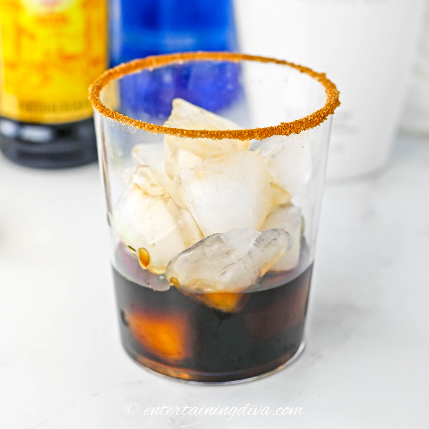 A rimmed glass filled with ice and some Kahlua