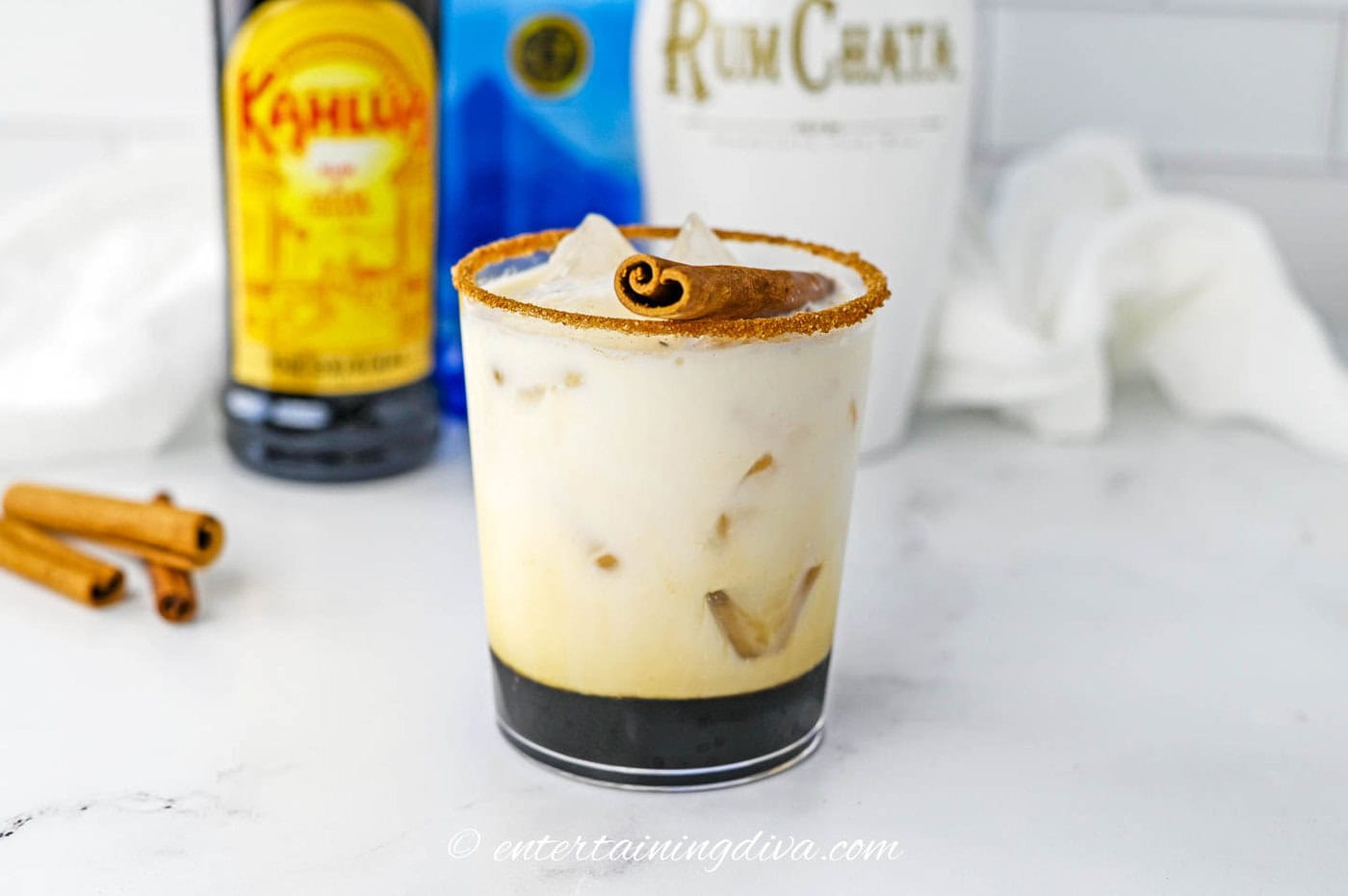 A RumChata White Russian with a cinnamon stick garnish