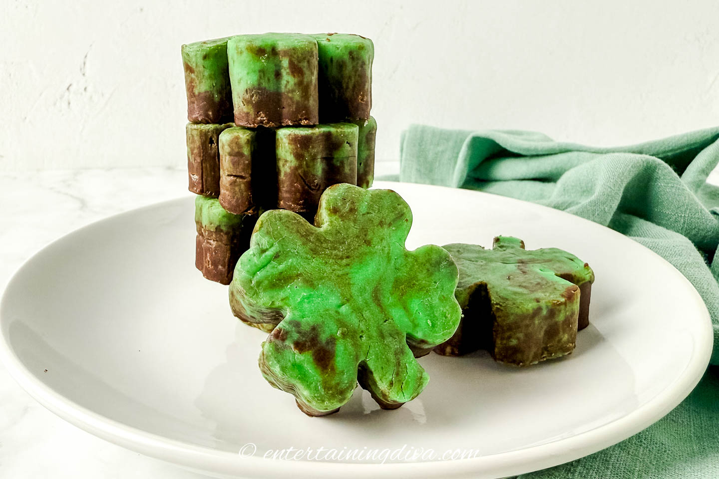 side view of shamrock mint chocolate fudge stacked on a plate