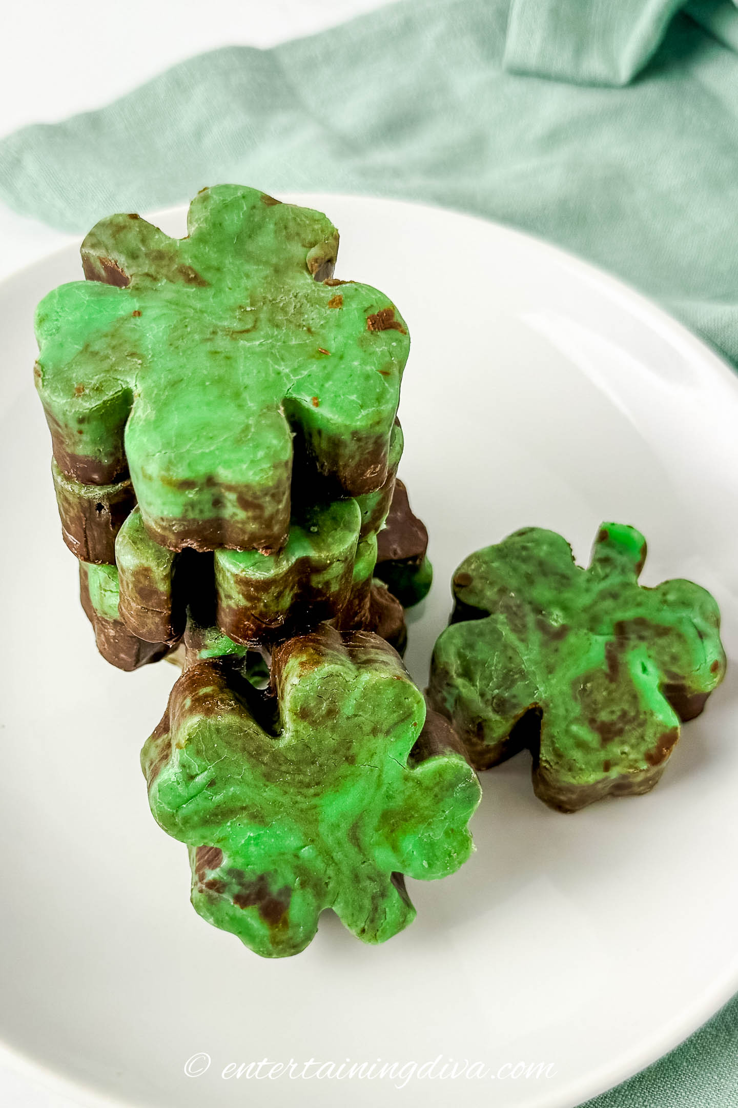 4 pieces of shamrock mint chocolate fudge stacked on a plate