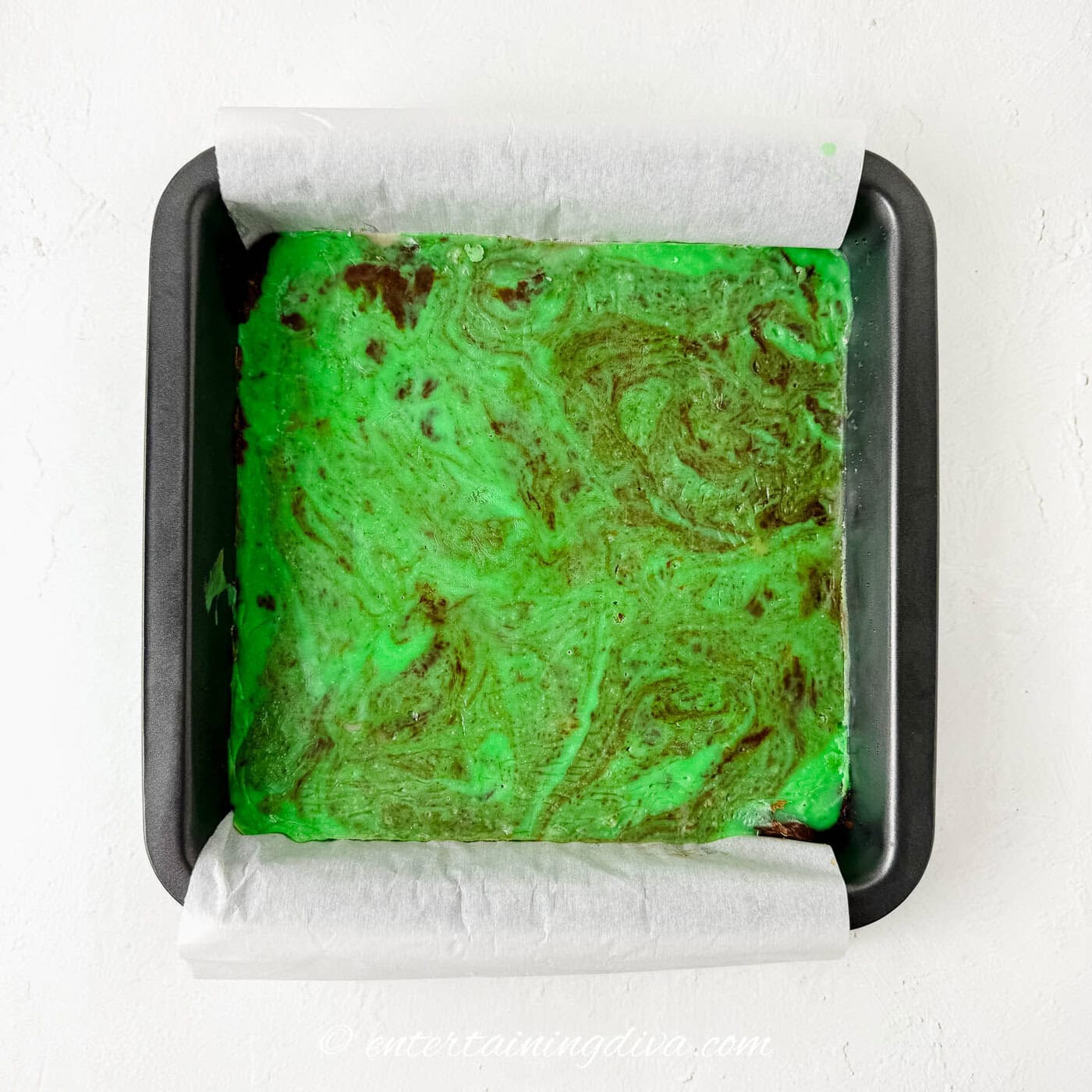 The swirled green fudge in a cake pan before chilling