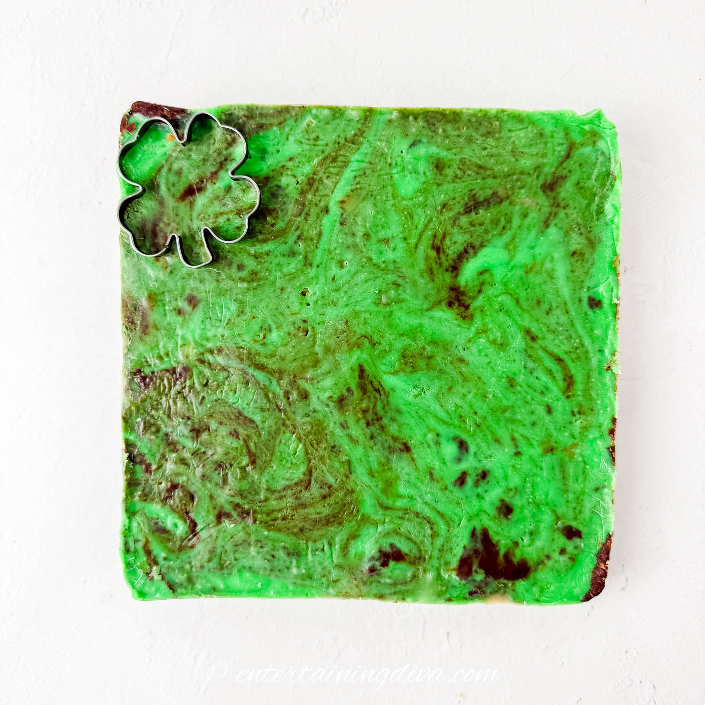 A shamrock cookie cutter on top of green mint chocolate fudge
