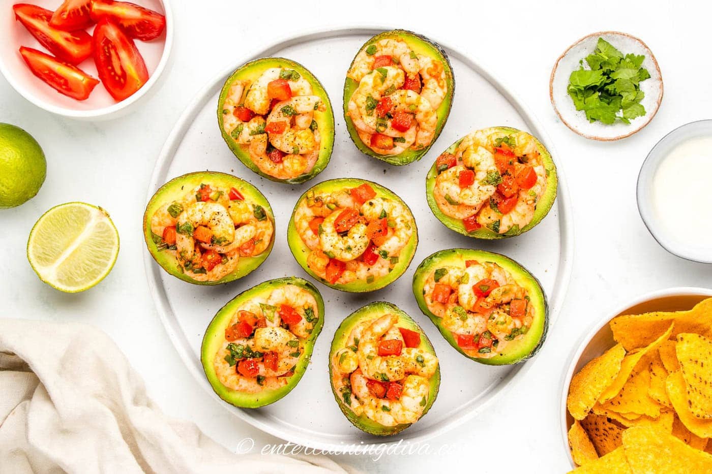 shrimp stuffed avocados served with tortilla chips, sour cream, cilantro, tomatoes and limes