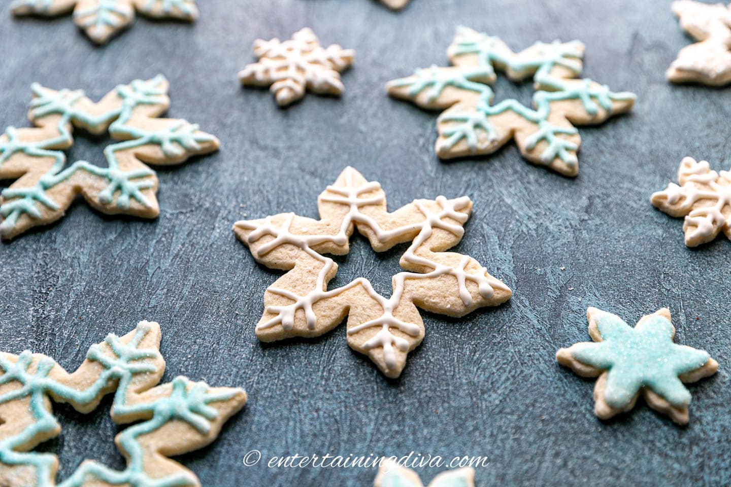 Snowflake sugar cookies arranged on a table.