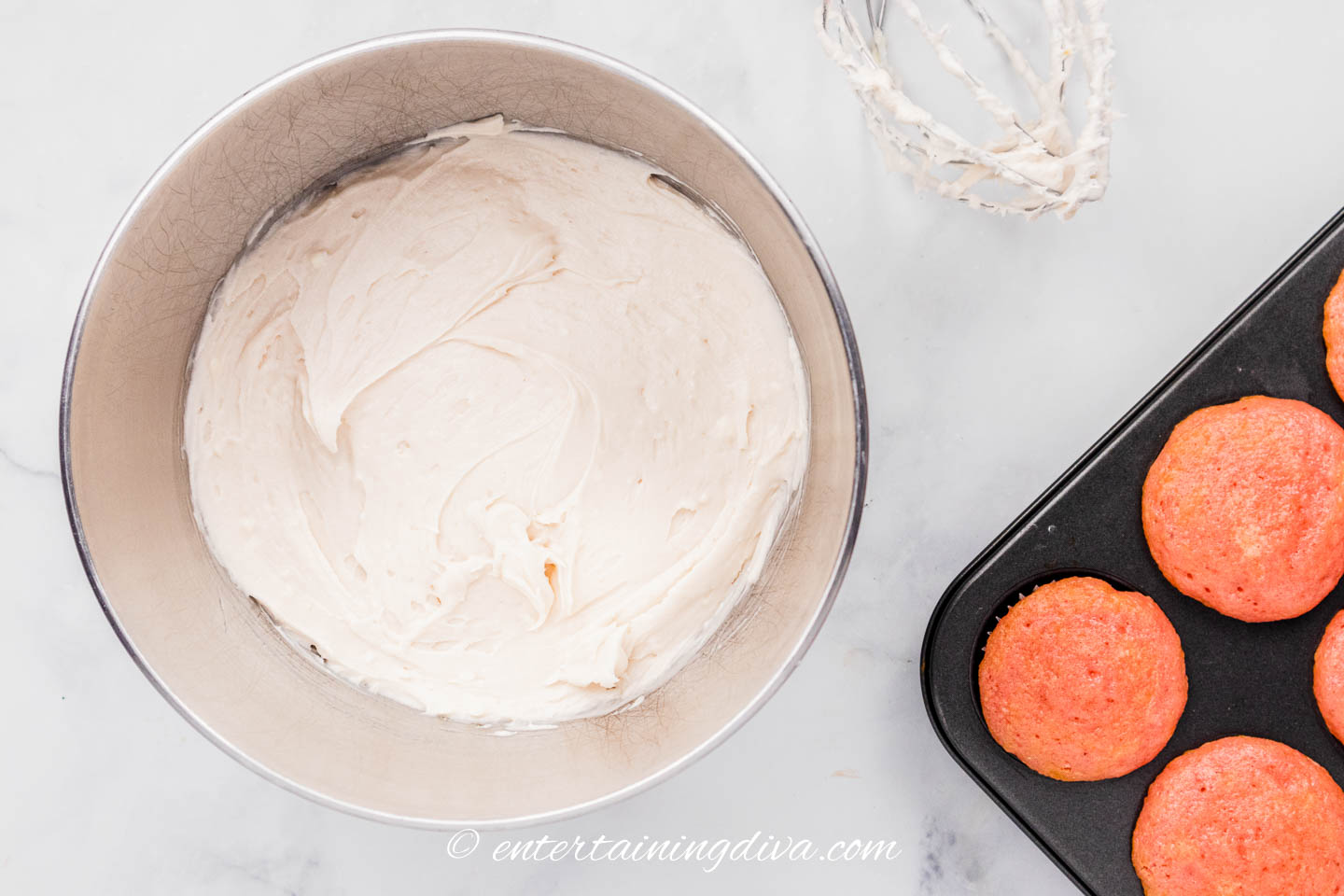 strawberry cream cheese frosting in a bowl beside strawberry soda cupcakes