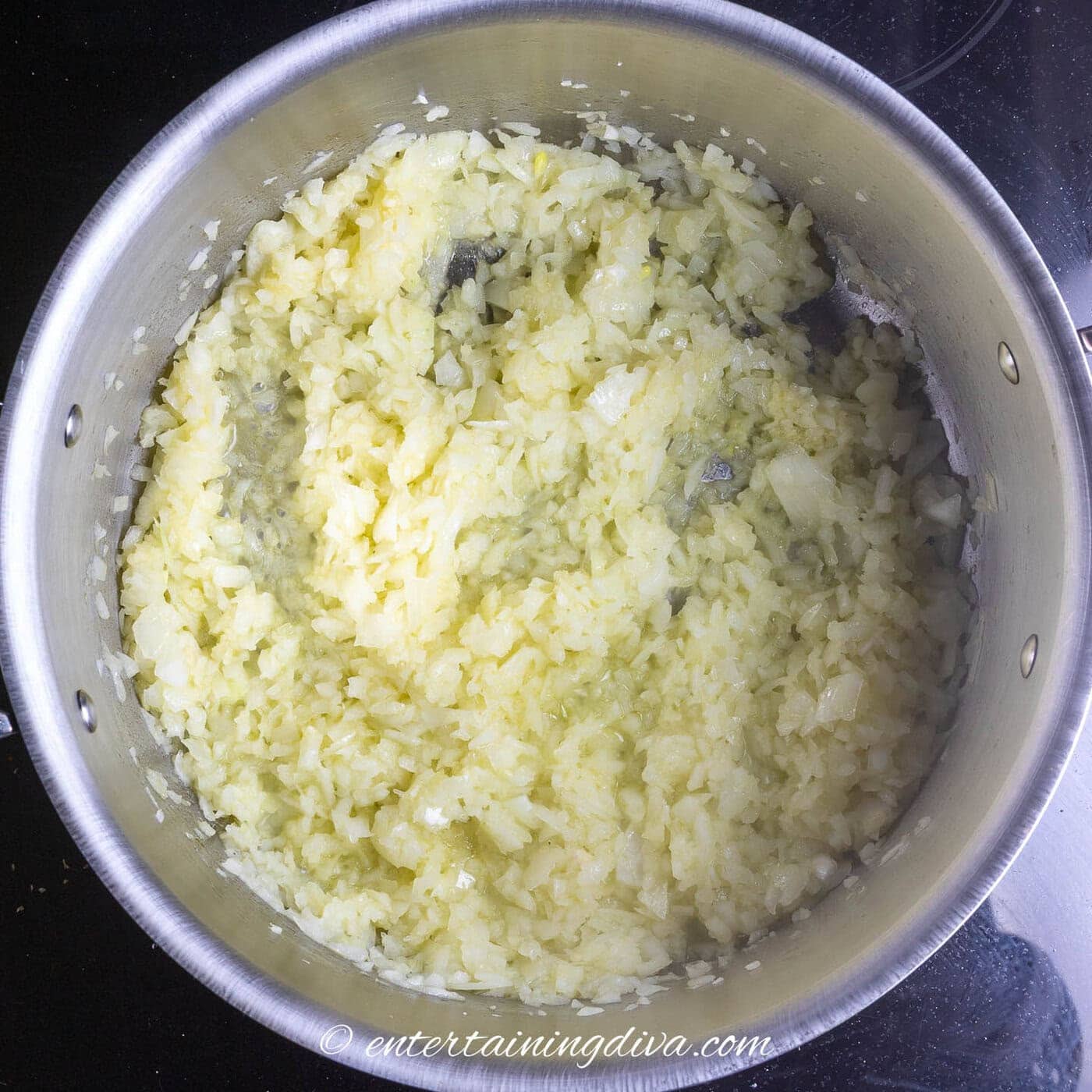 onions and garlic being sauteed in a stock pot