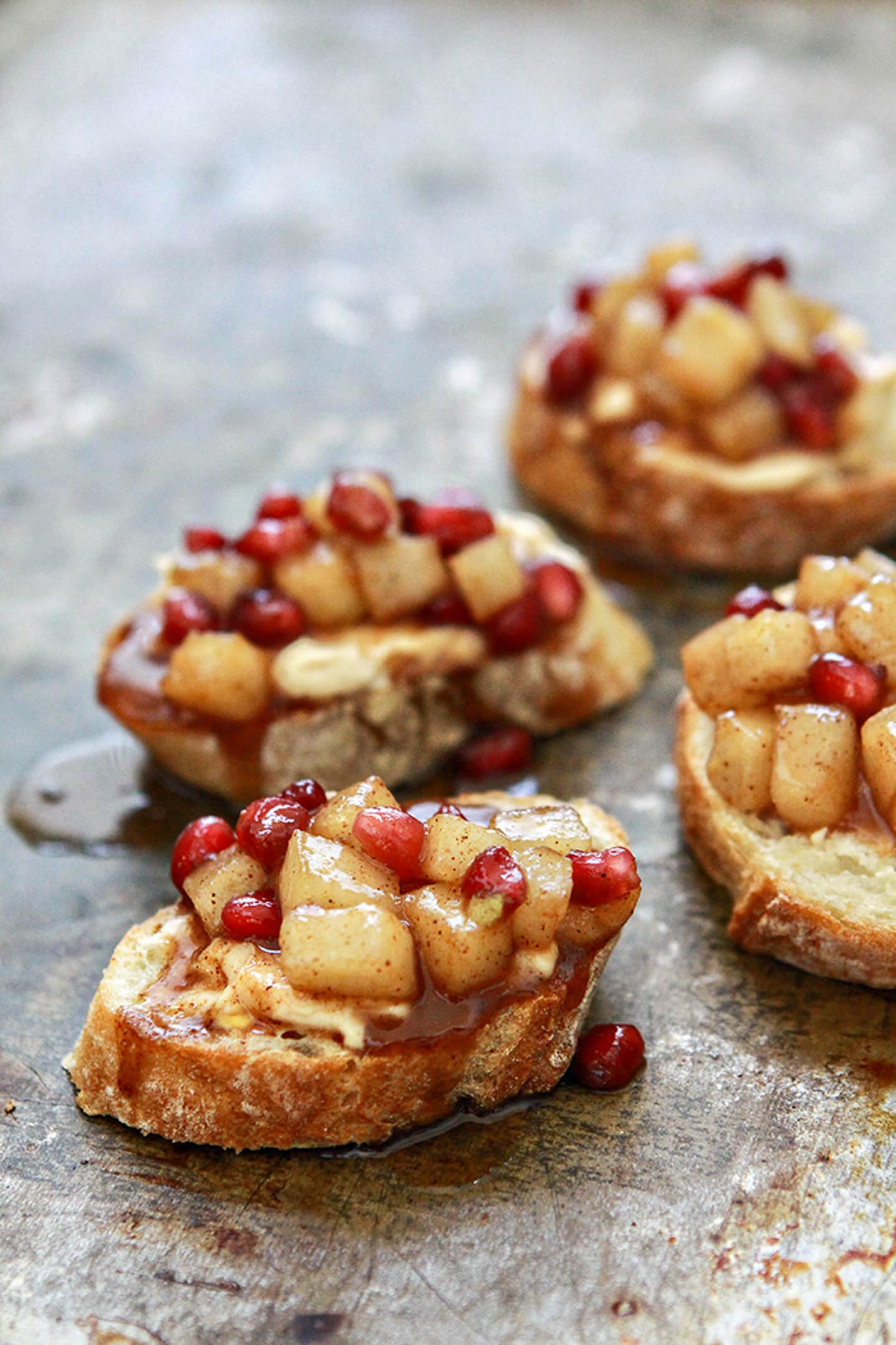 Four slices of bread with pomegranate on them.