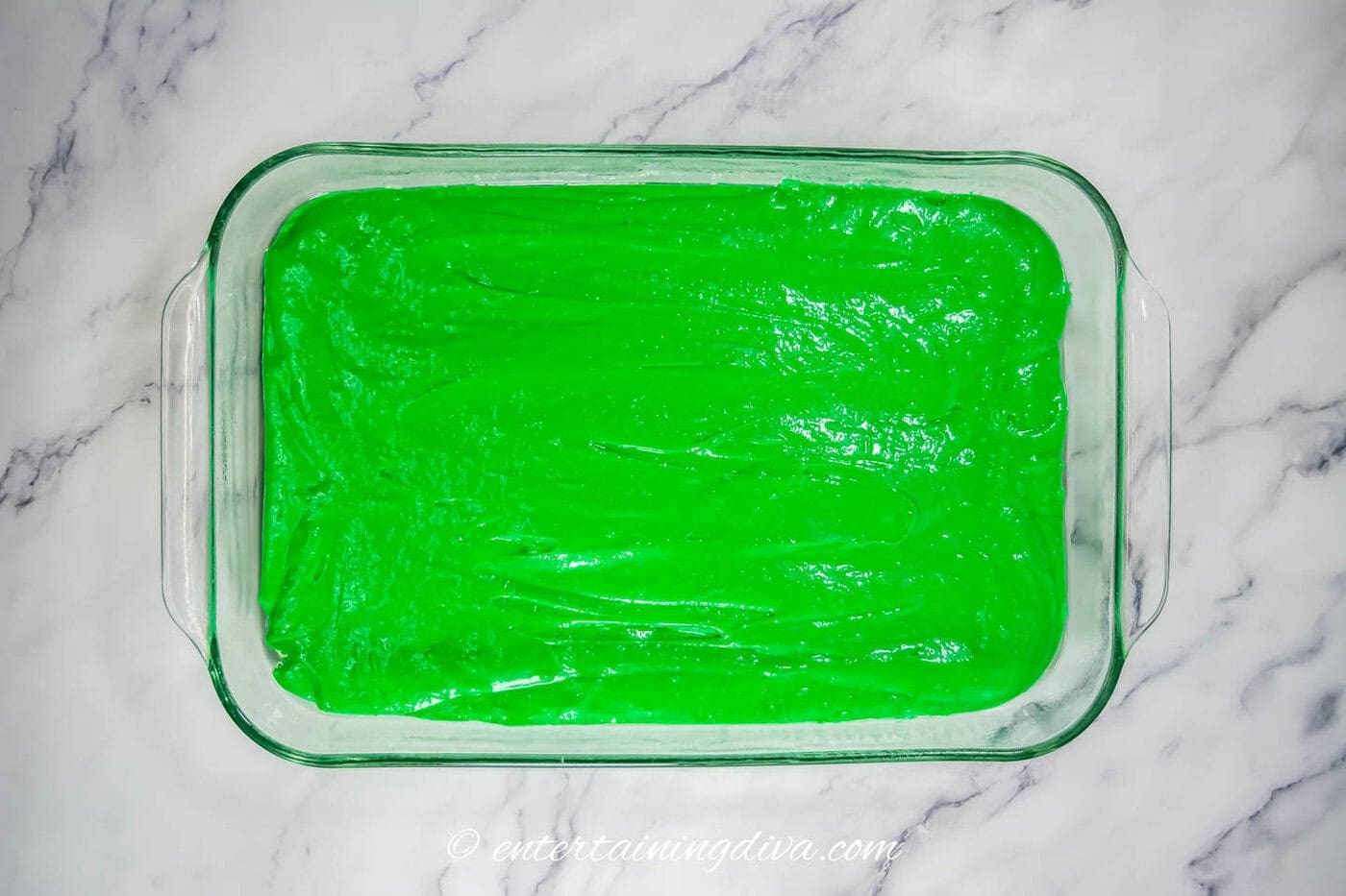 green cake batter in a 9" x 13" baking pan