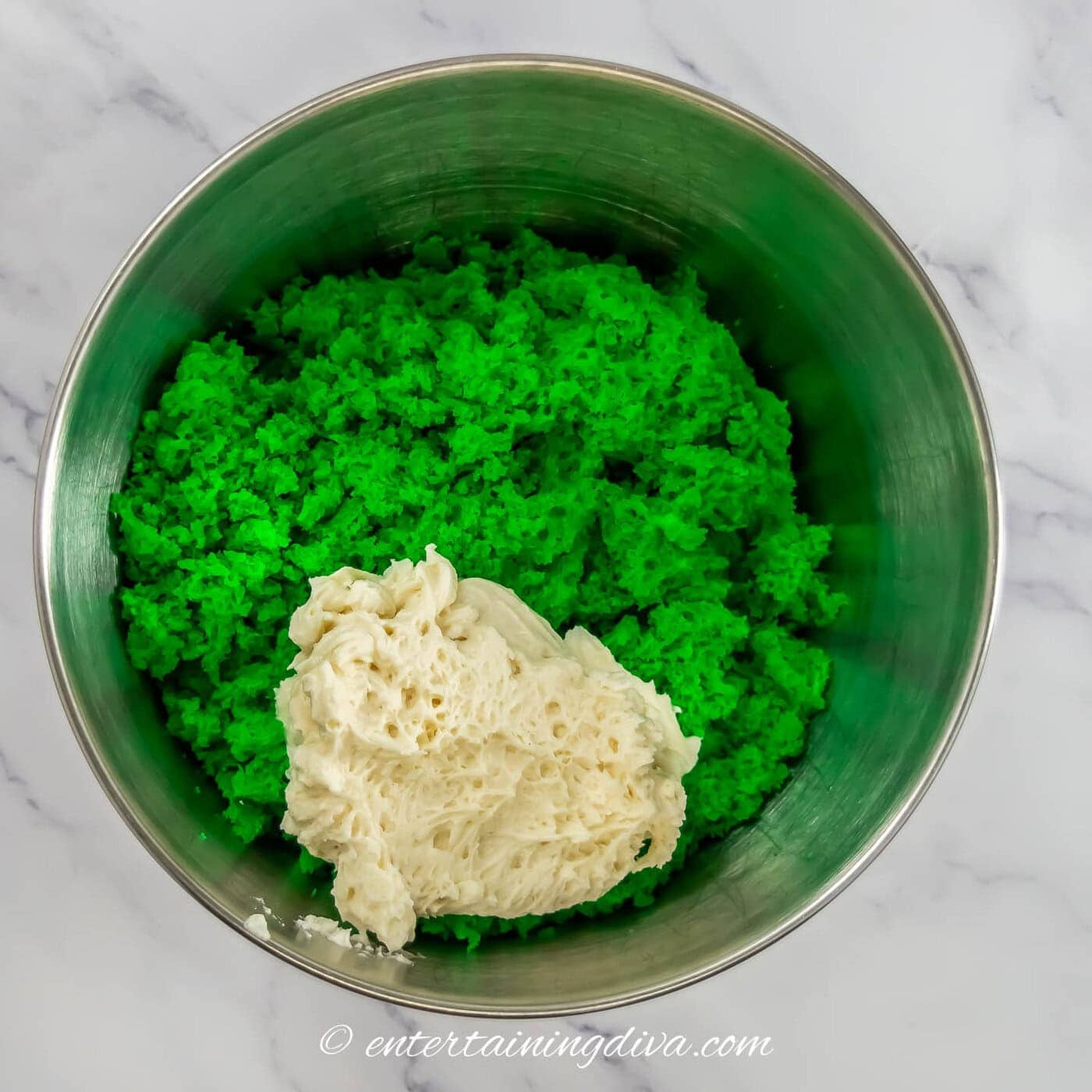 crumbled green cake with white frosting in a bowl