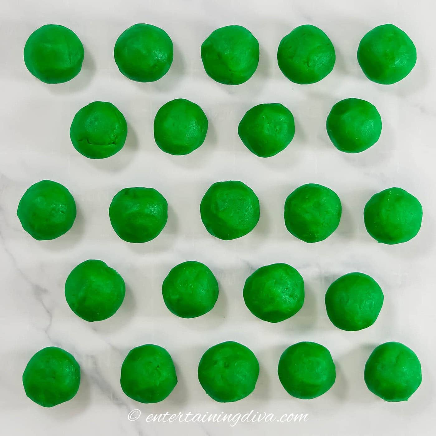 green cake balls on a piece of parchment paper