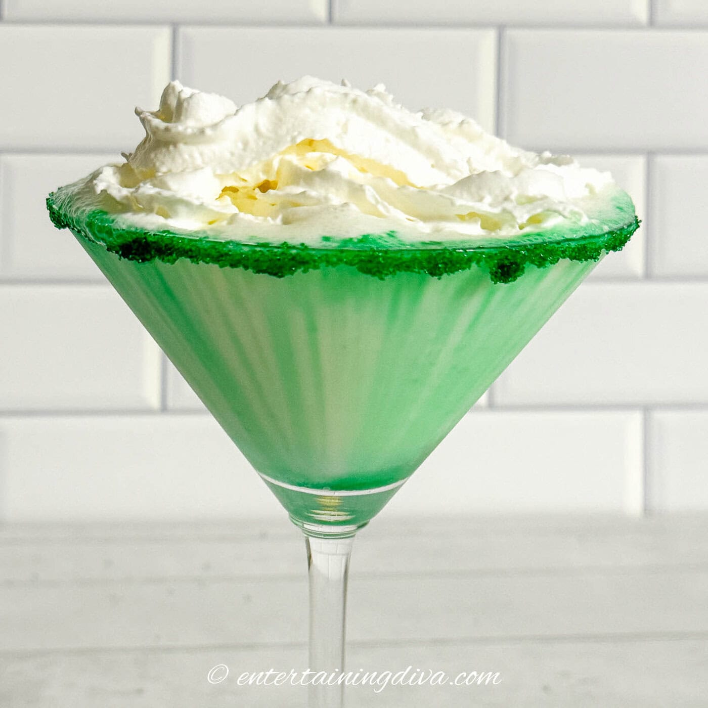 Close up of a St Patrick's Day Martini topped with whipped cream