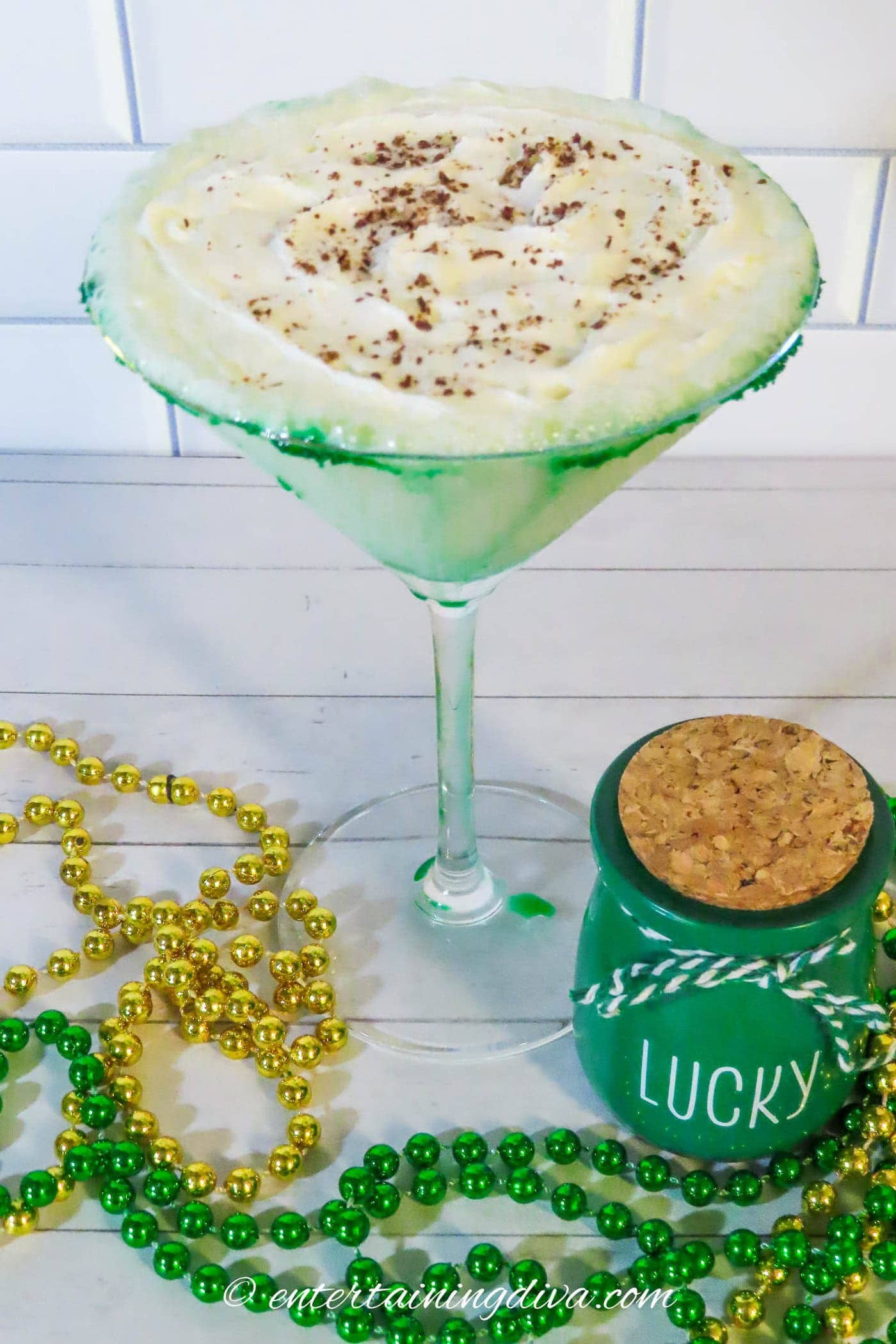 St Patrick's Day martini beside a green jar and gold and green beads