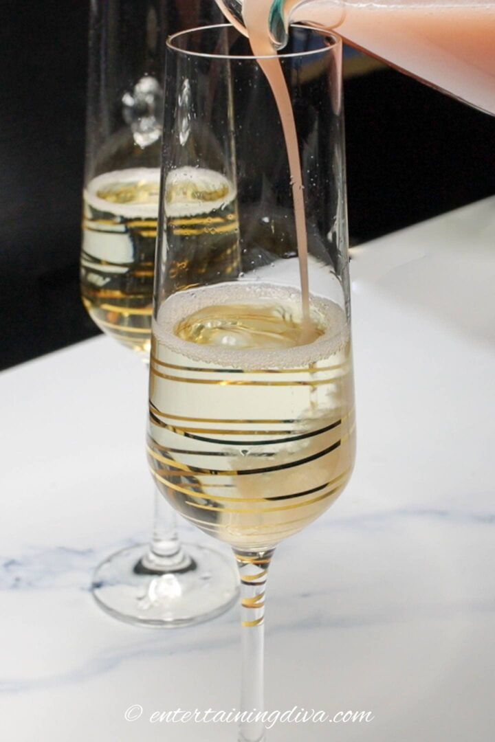 strawberry juice being poured into glass with sparkling wine