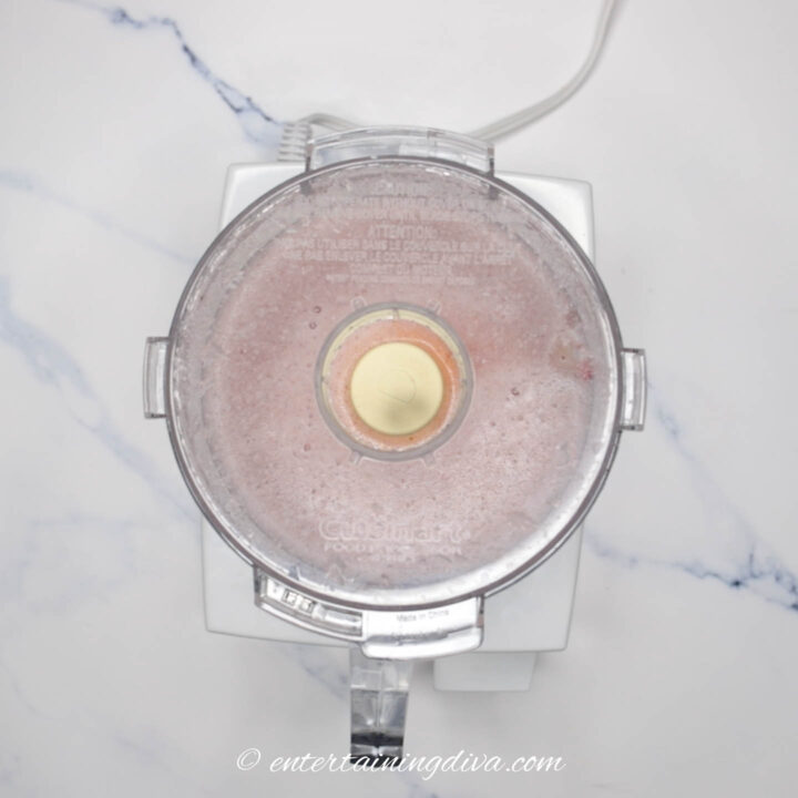 Strawberries, sparkling wine and sugar being blended in a food processor