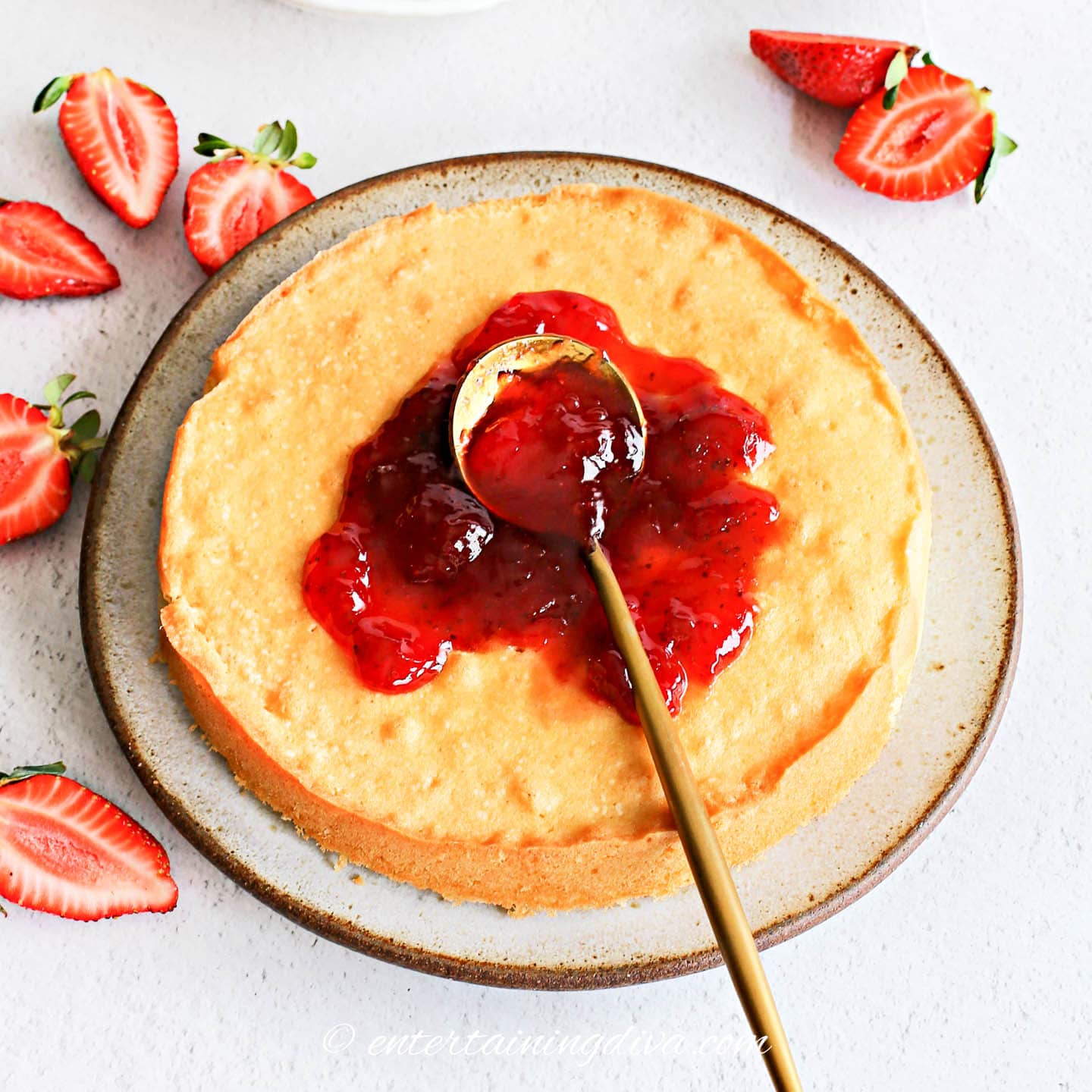 Bottom layer of cake spread with strawberry preserves