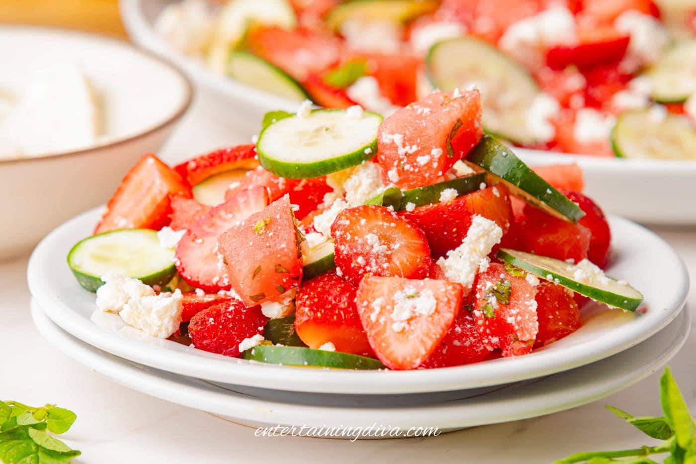 A side view of strawberry watermelon cucumber salad on a plate