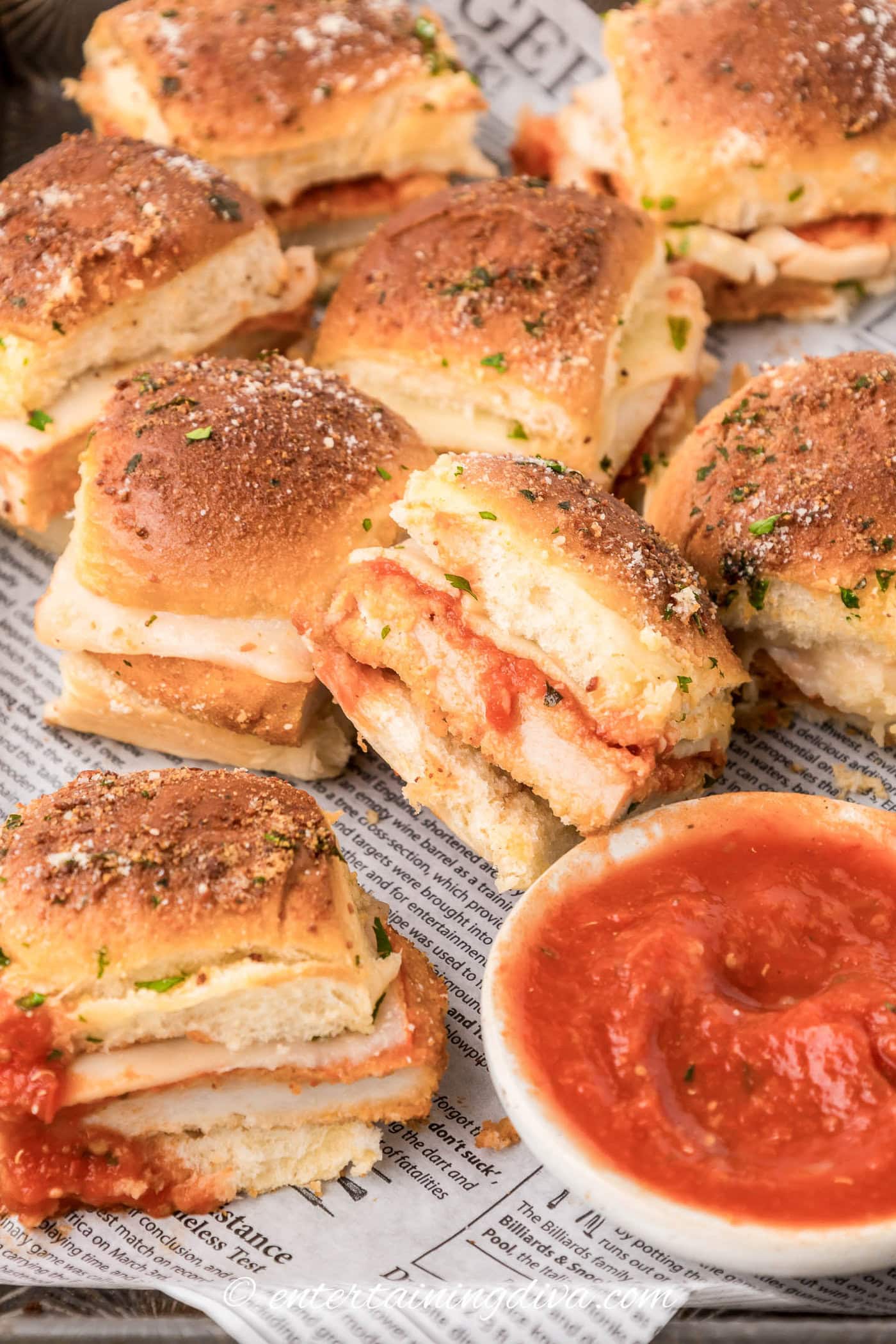 chicken parmesan sliders in a baking dish with one turned sidewise