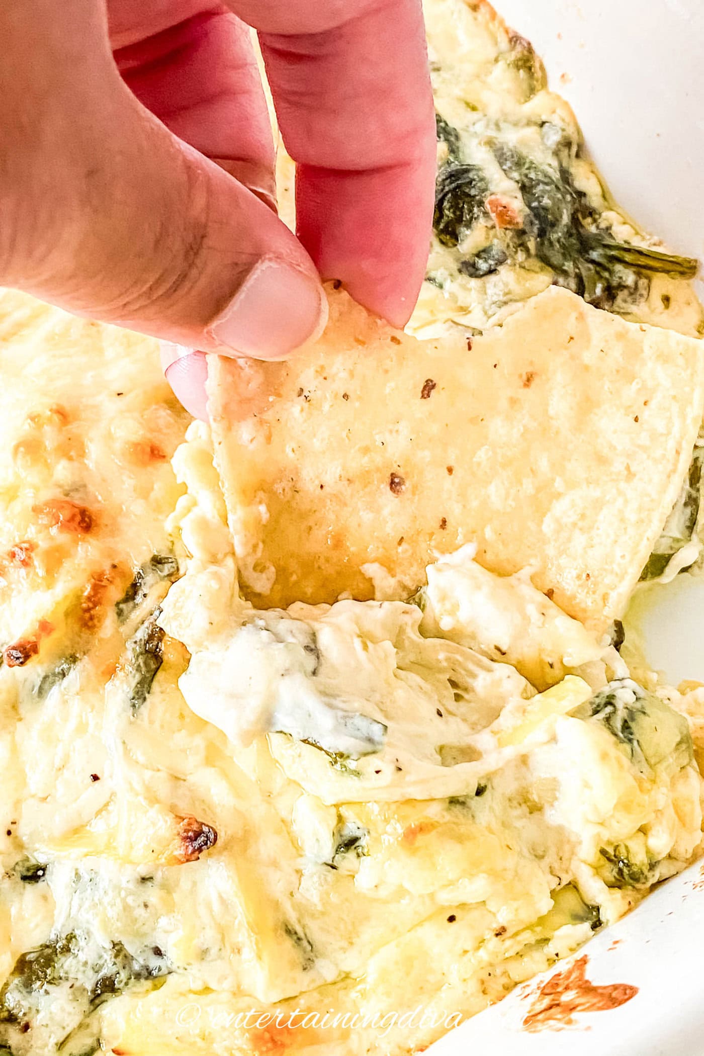 hot spinach artichoke dip on a tortilla chip