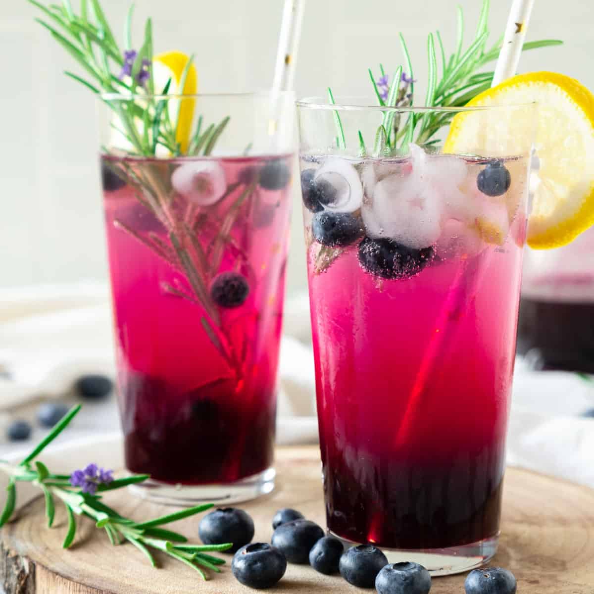 Two tall glasses of blueberry vodka lemonade