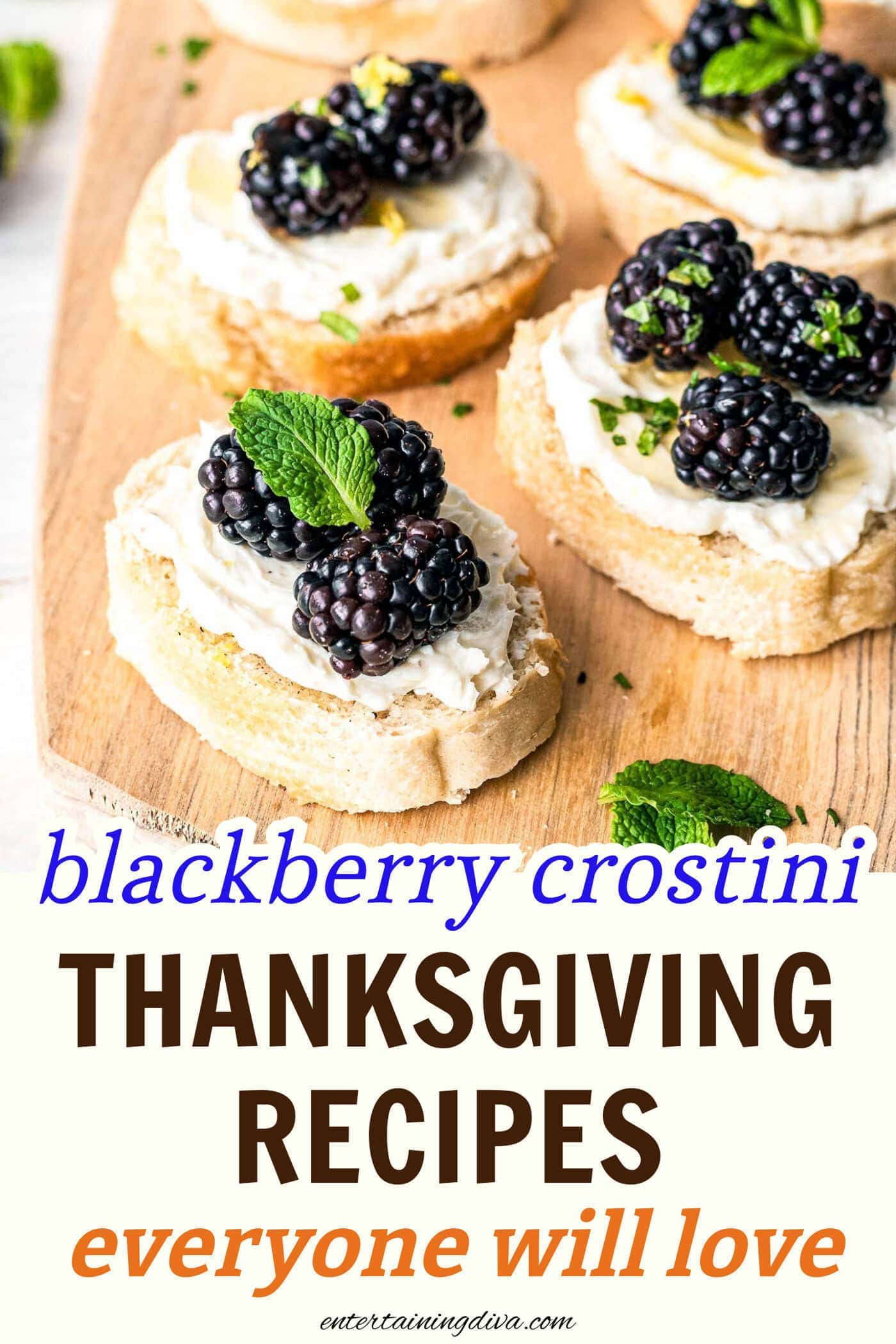 close up of 3 blackberry goat cheese crostini appetizers garnished with mint leaves on a cutting board