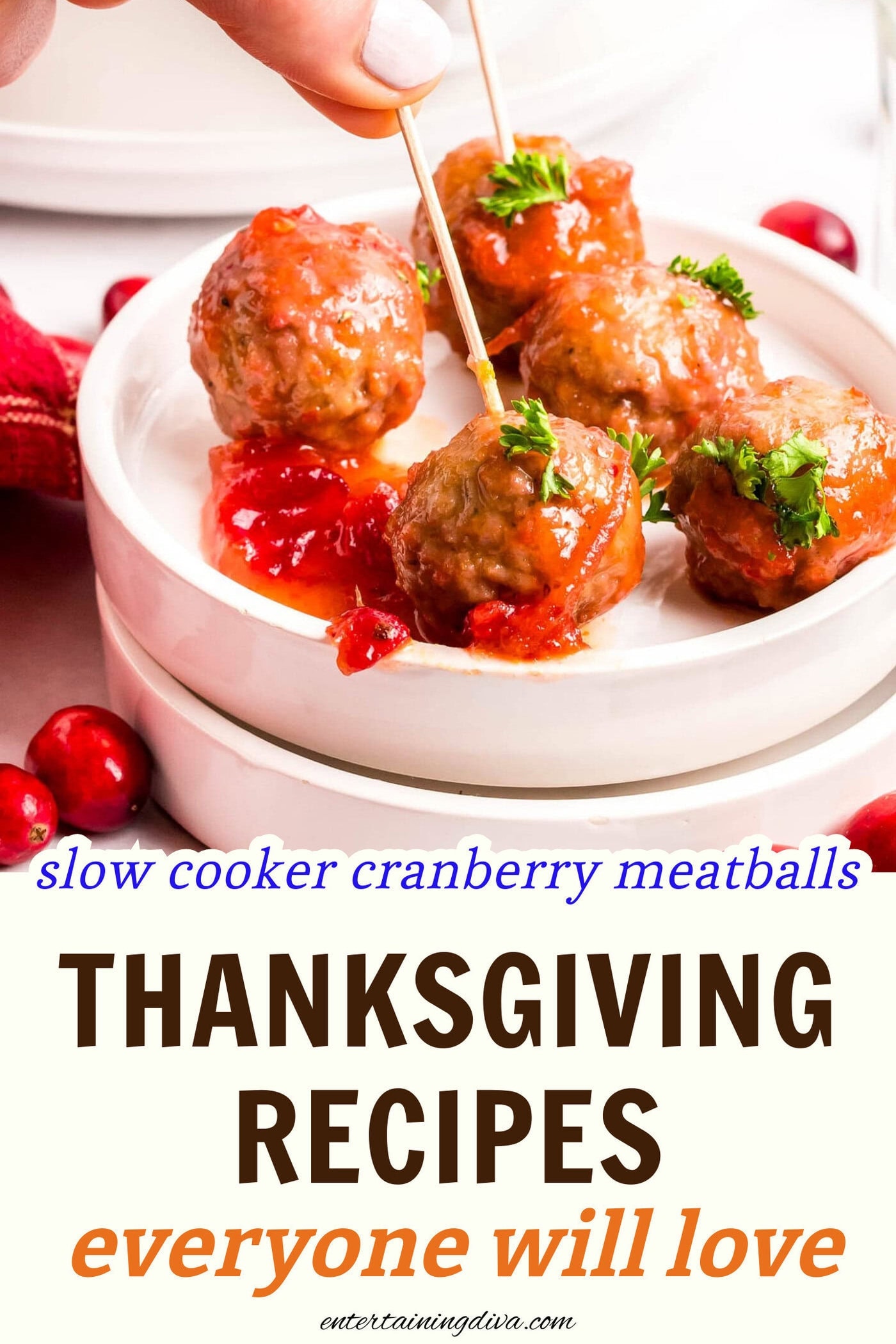 cranberry meatballs on a dish being picked up with a toothpick
