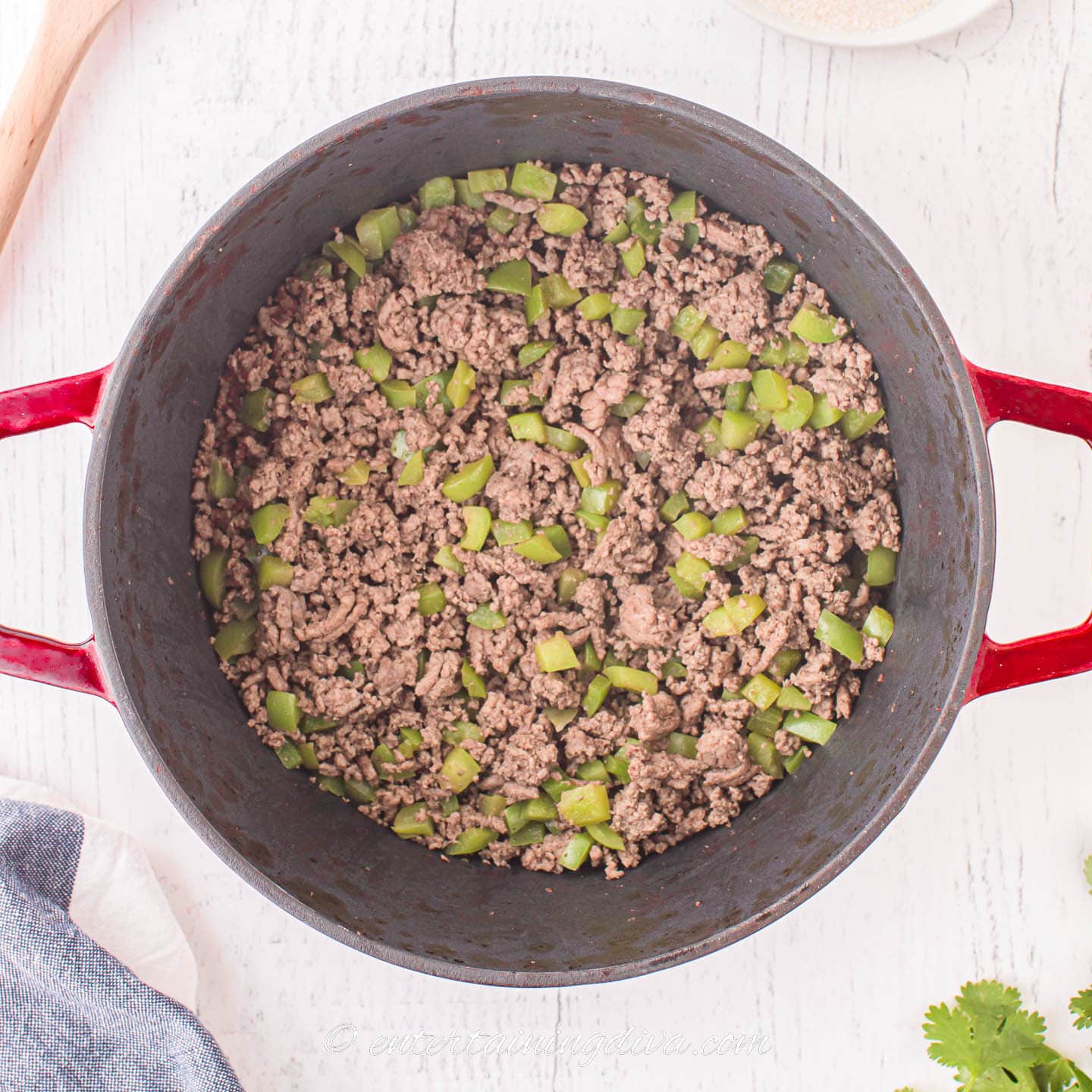 browned ground beef and green bell pepper in a dutch oven