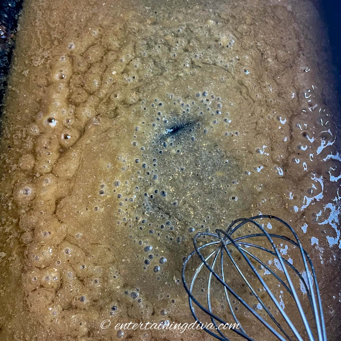 turkey gravy being simmered in a roasting pan
