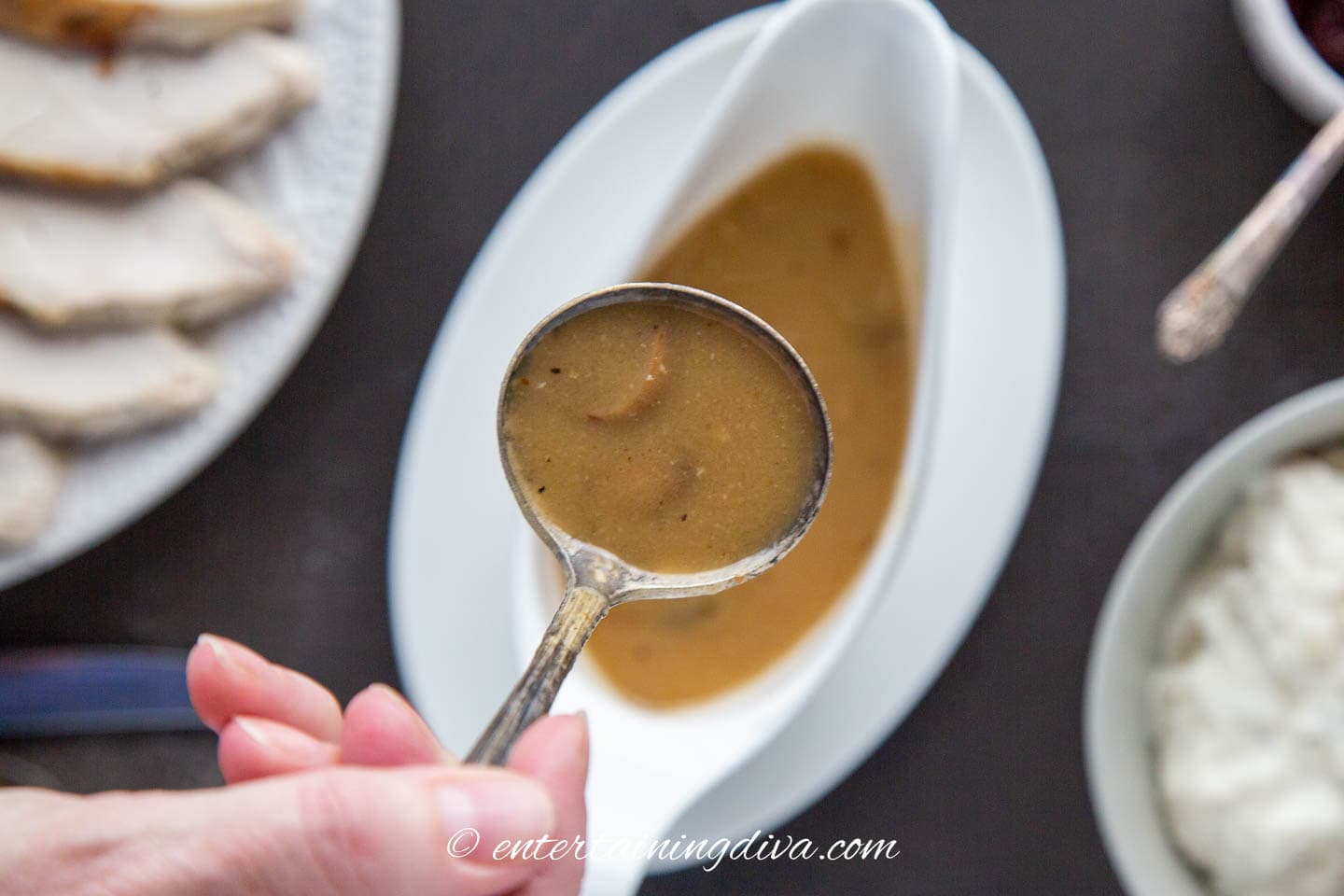 turkey gravy in a ladle above a gravy boat