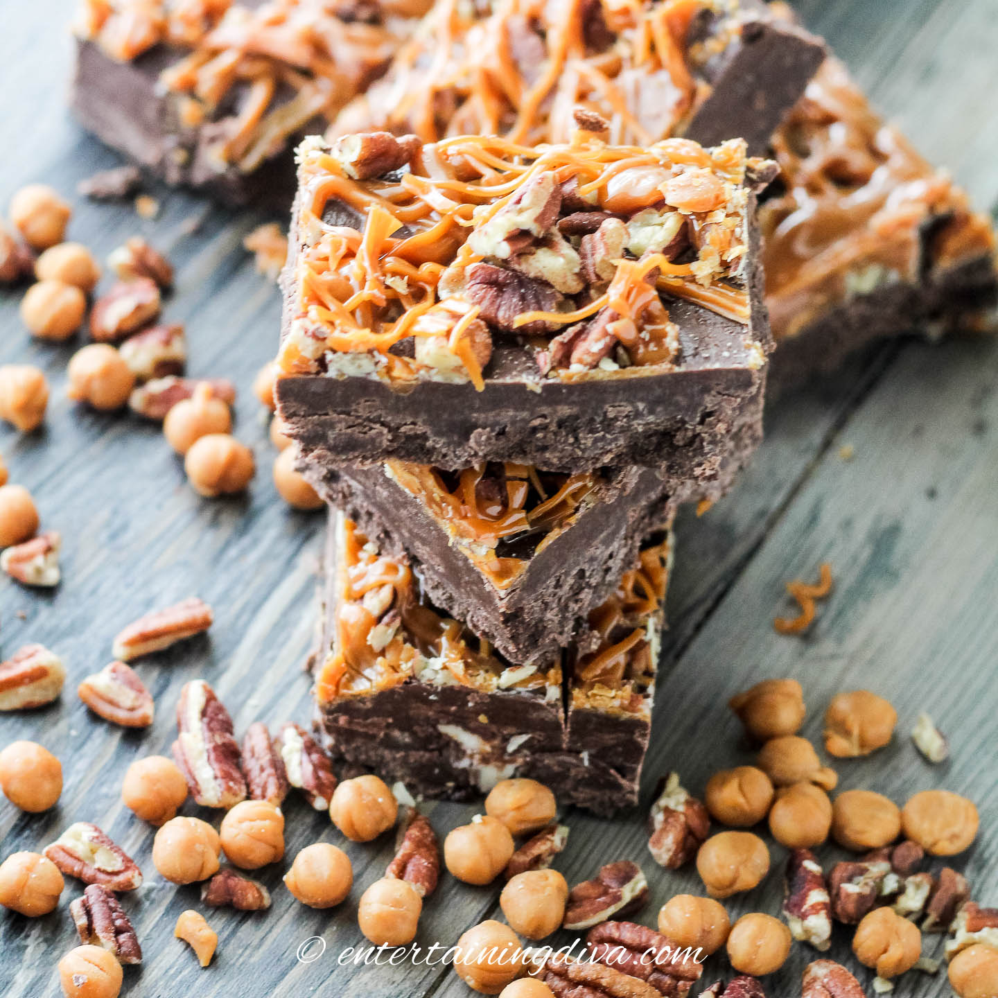 squares of turtle cream cheese fudge stacked on top of each other