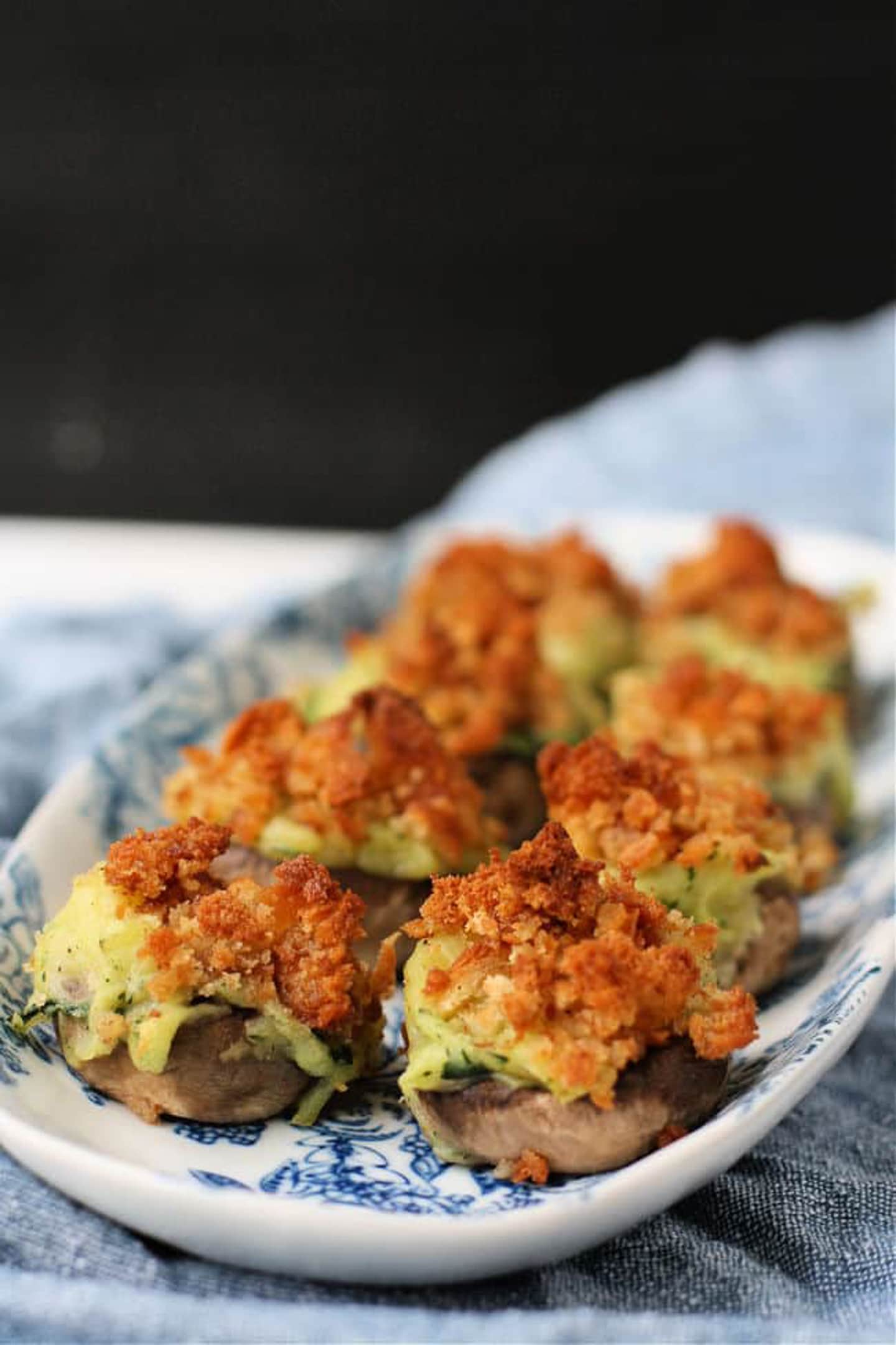 Stuffed mushrooms on a blue and white plate.