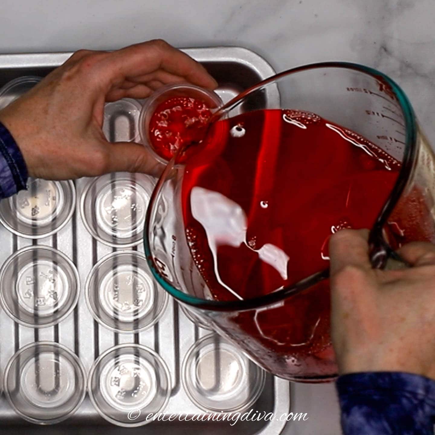 Jello shot mixture being poured into Jello shot cups