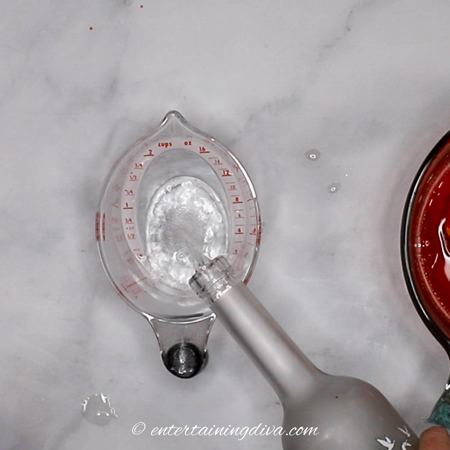 Vodka being poured into a measuring cup
