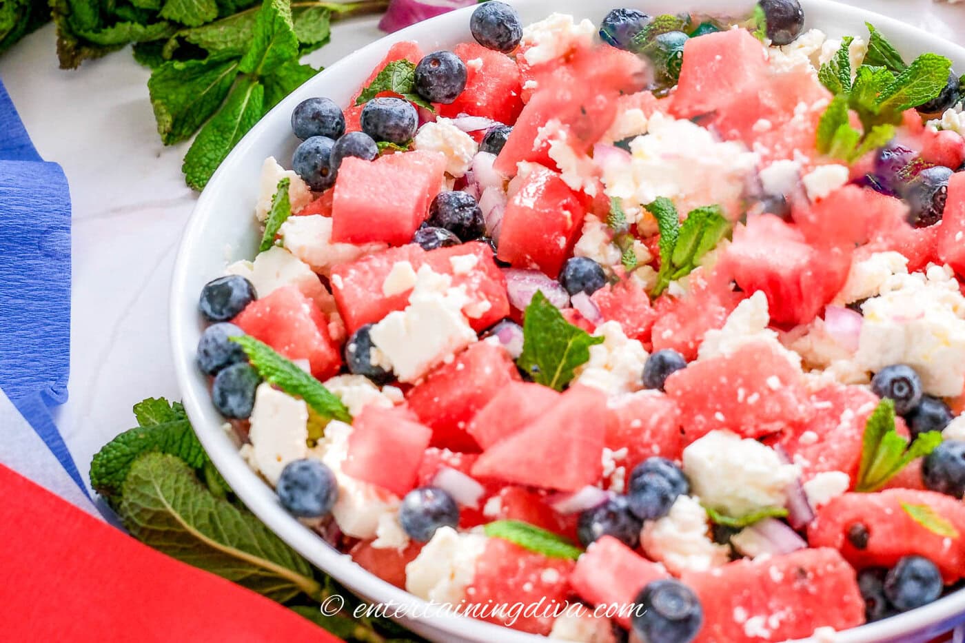 Watermelon feta salad in a bowl with red and blue ribbons