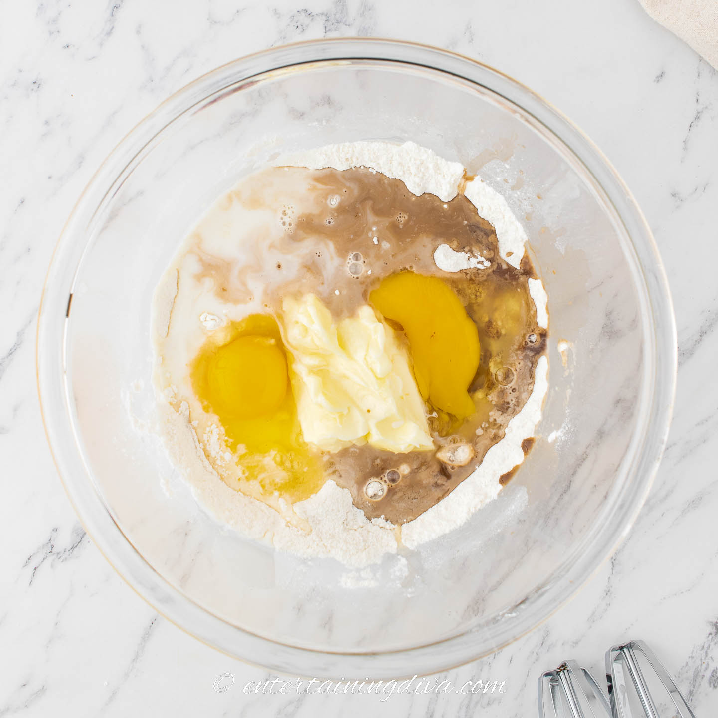 cupcake wet ingredients with dry ingredients in a mixing bowl