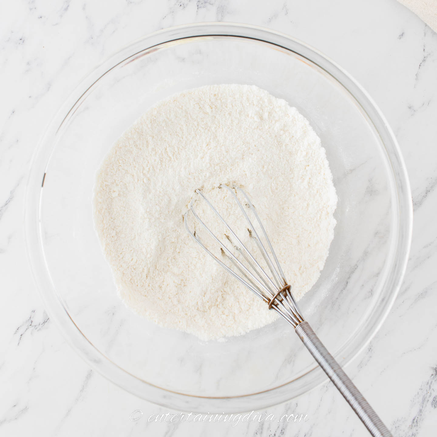 flour and other dry cupcake ingredients in a bowl with a whisk