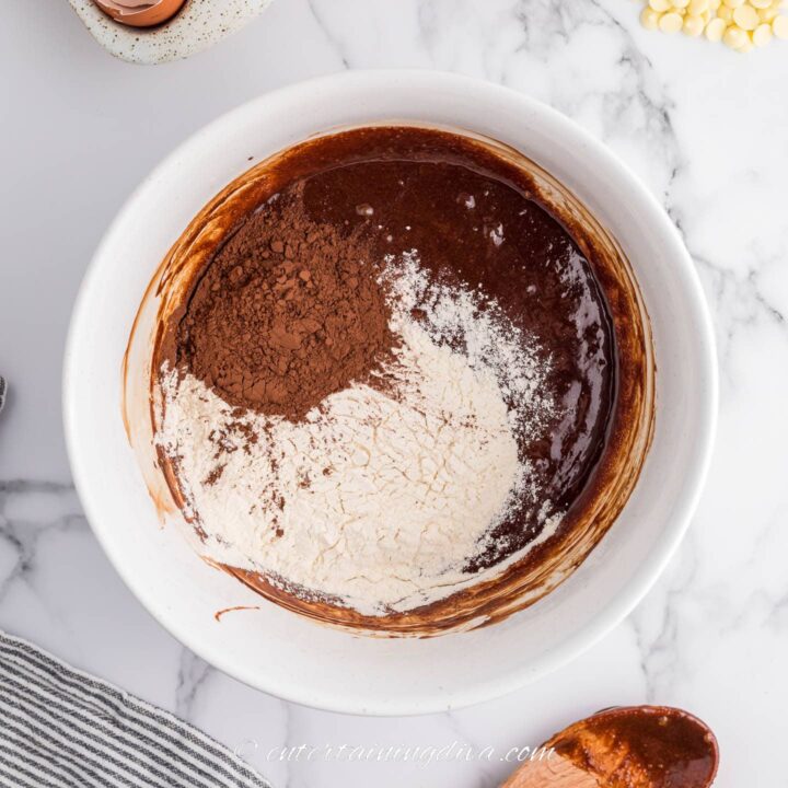 flour and cocoa powder with chocolate mixture in a bowl