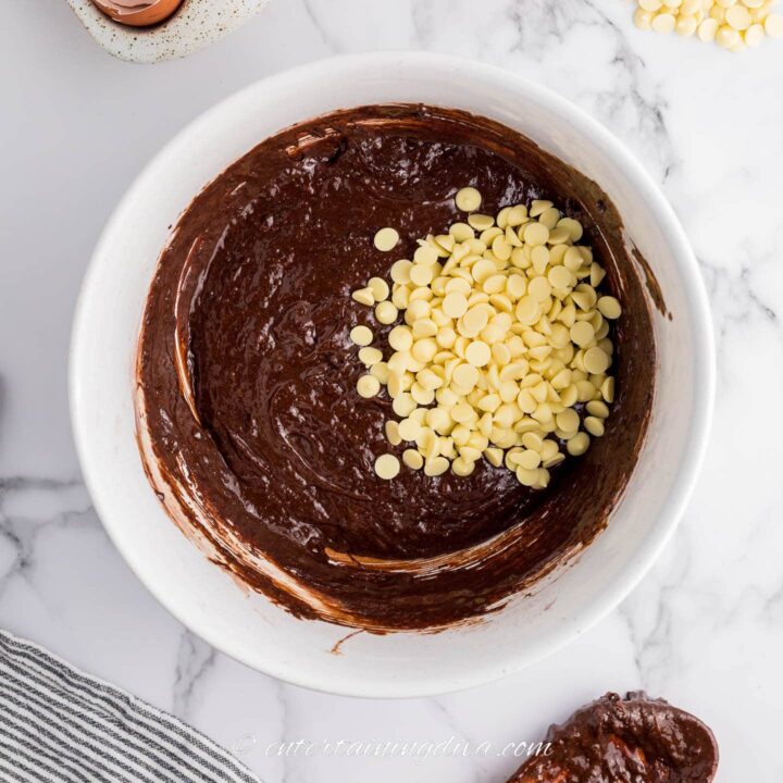white chocolate chips in brownie batter in a bowl