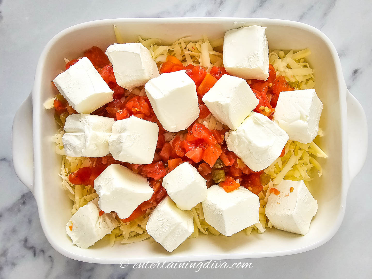 Grated pepper jack cheese, rotel and cream cheese in a baking dish