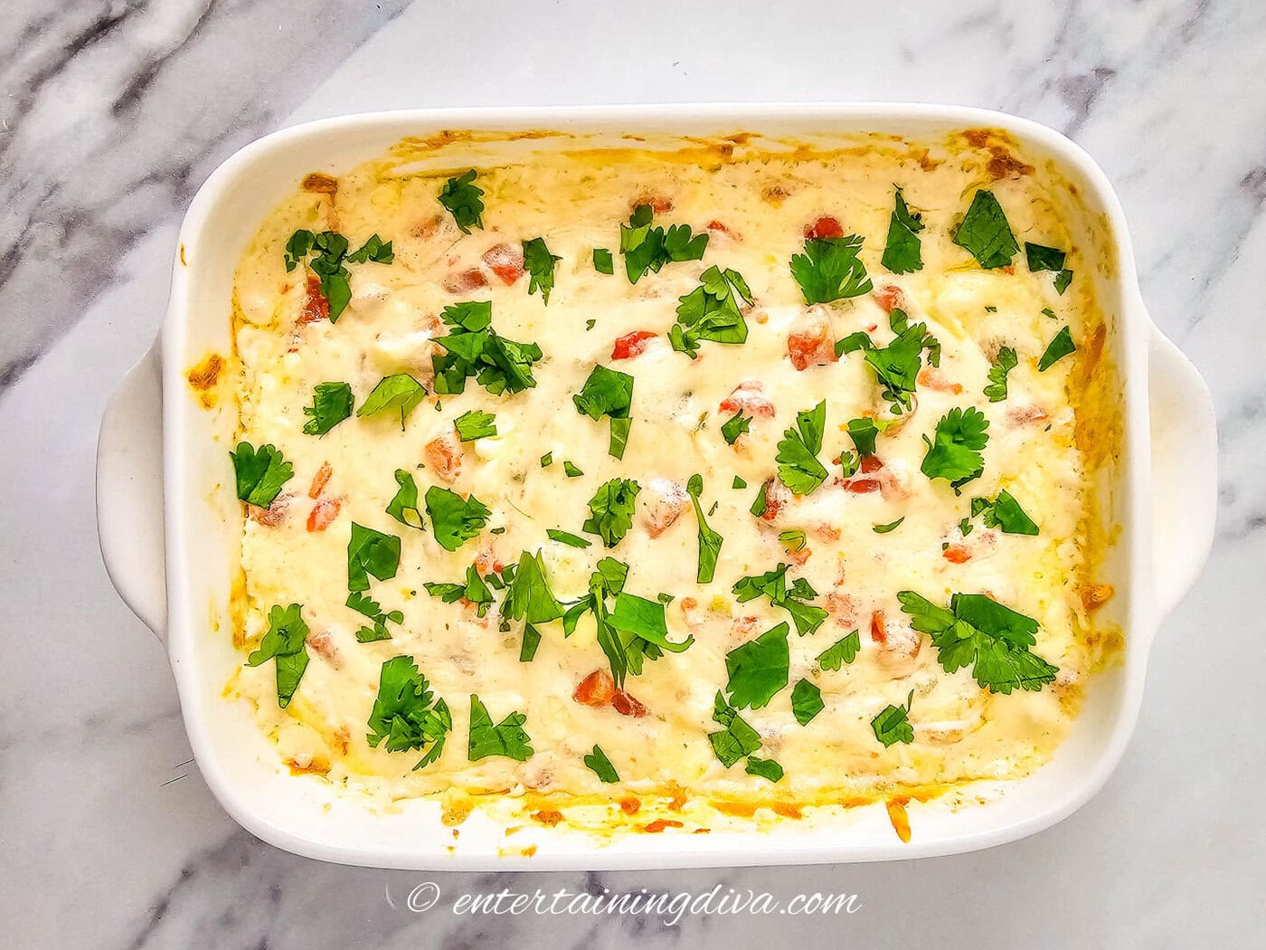 white queso in a baking dish with Cilantro garnish
