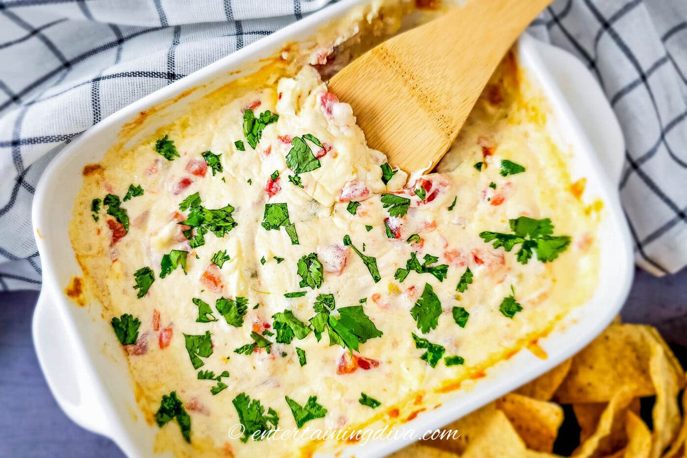 Mexican white cheese dip in a baking dish with a wooden spoon